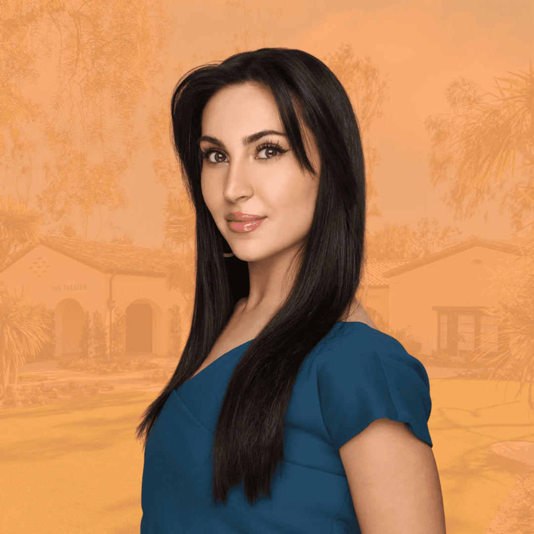 Smiling woman in beige linen outfit standing indoors with plants and books in the background.