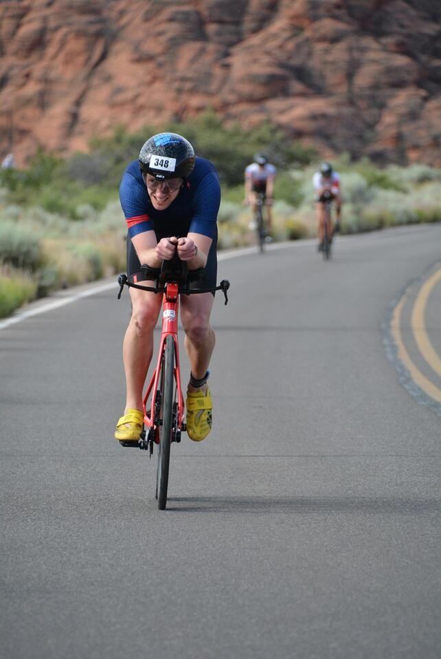 Triathlete in aero position on red tri bike