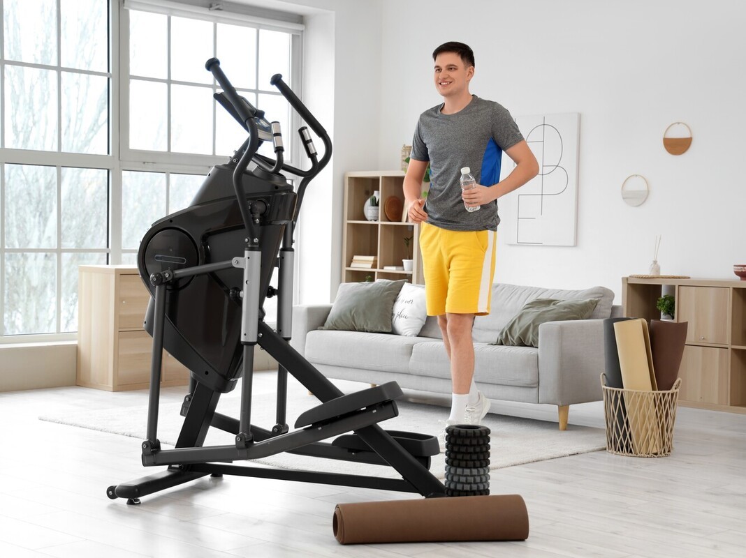 man getting ready to enjoy elliptical and weight loss benefits with his at-home machine