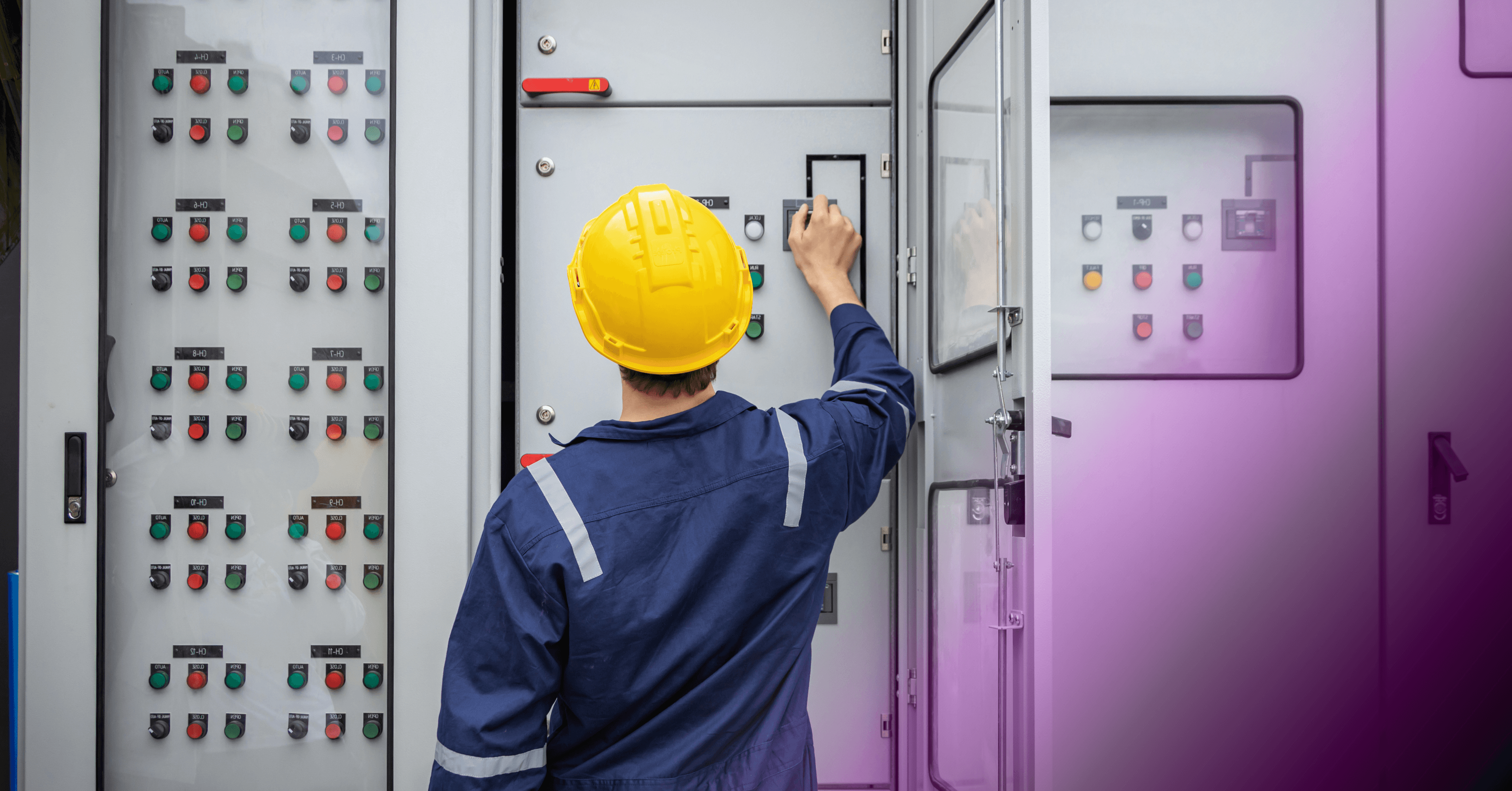 Utility company technician in a yellow hard hat operating an industrial electrical control panel.