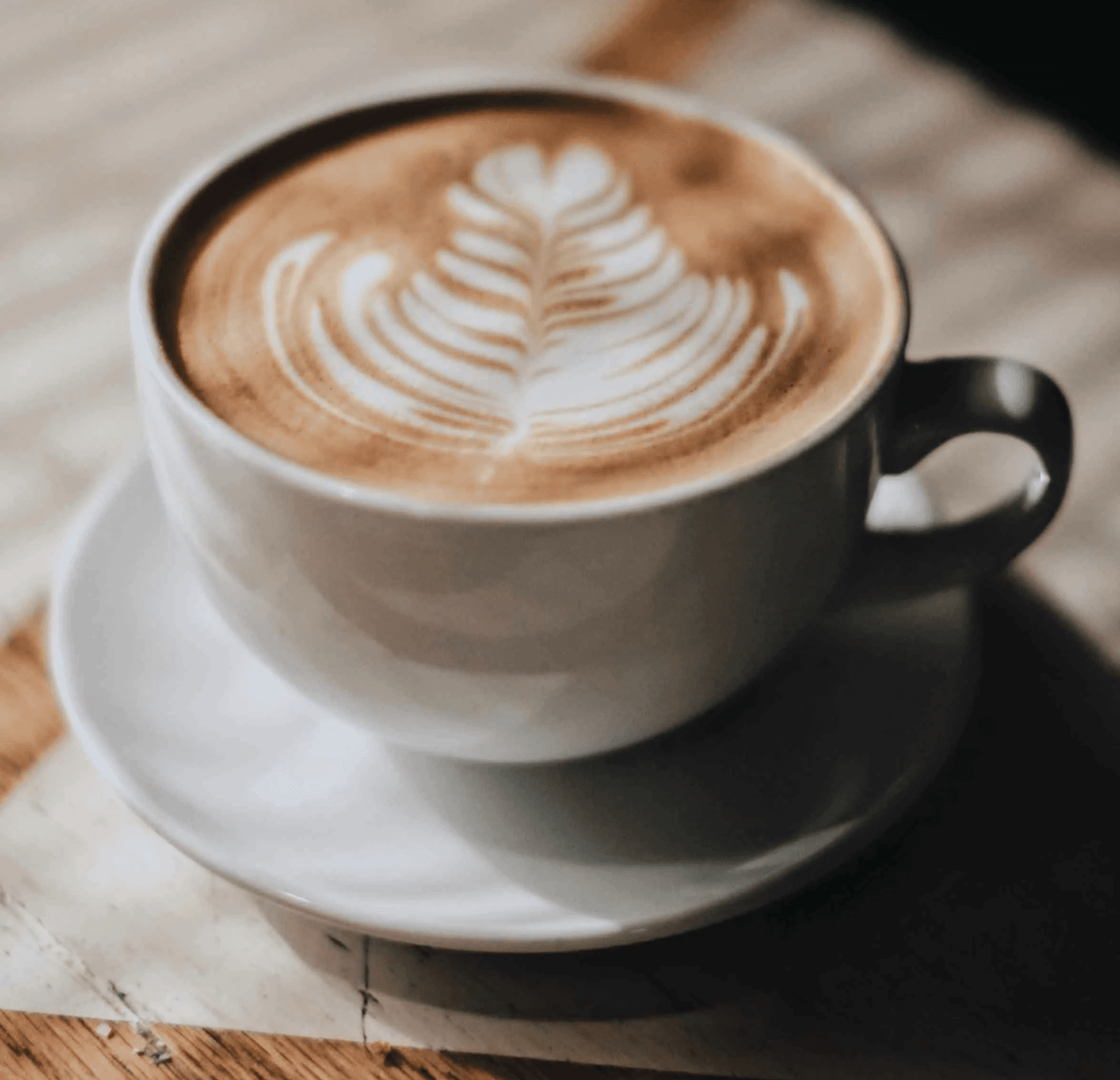 white ceramic cup with saucer on brown wooden table
