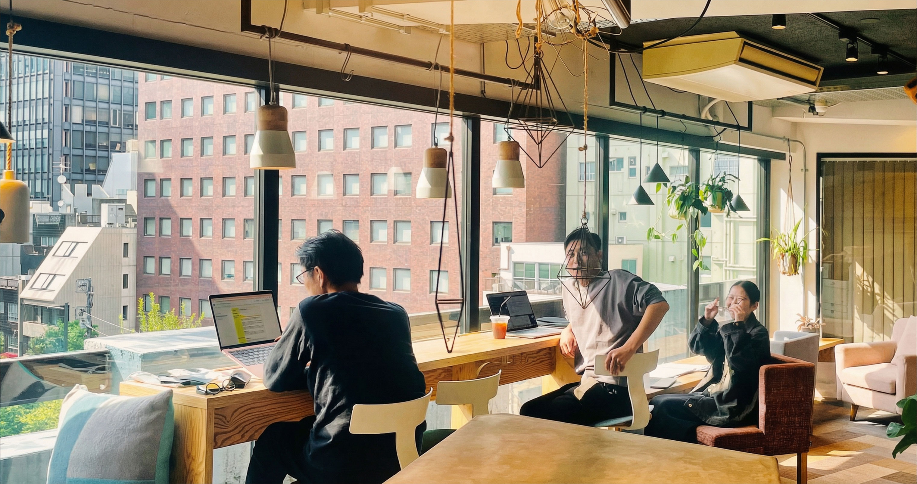 Black and white photo of two people looking at a computer screen with papers on wall