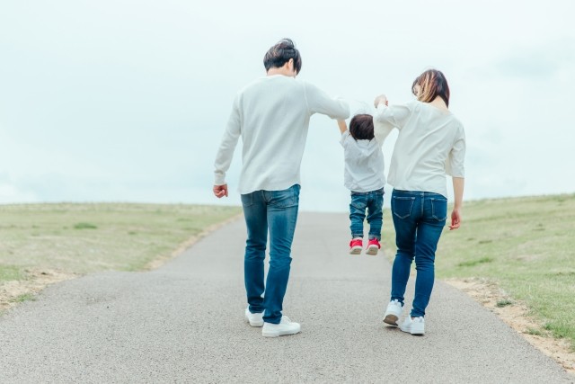 父と母の腕にぶら下がる子供