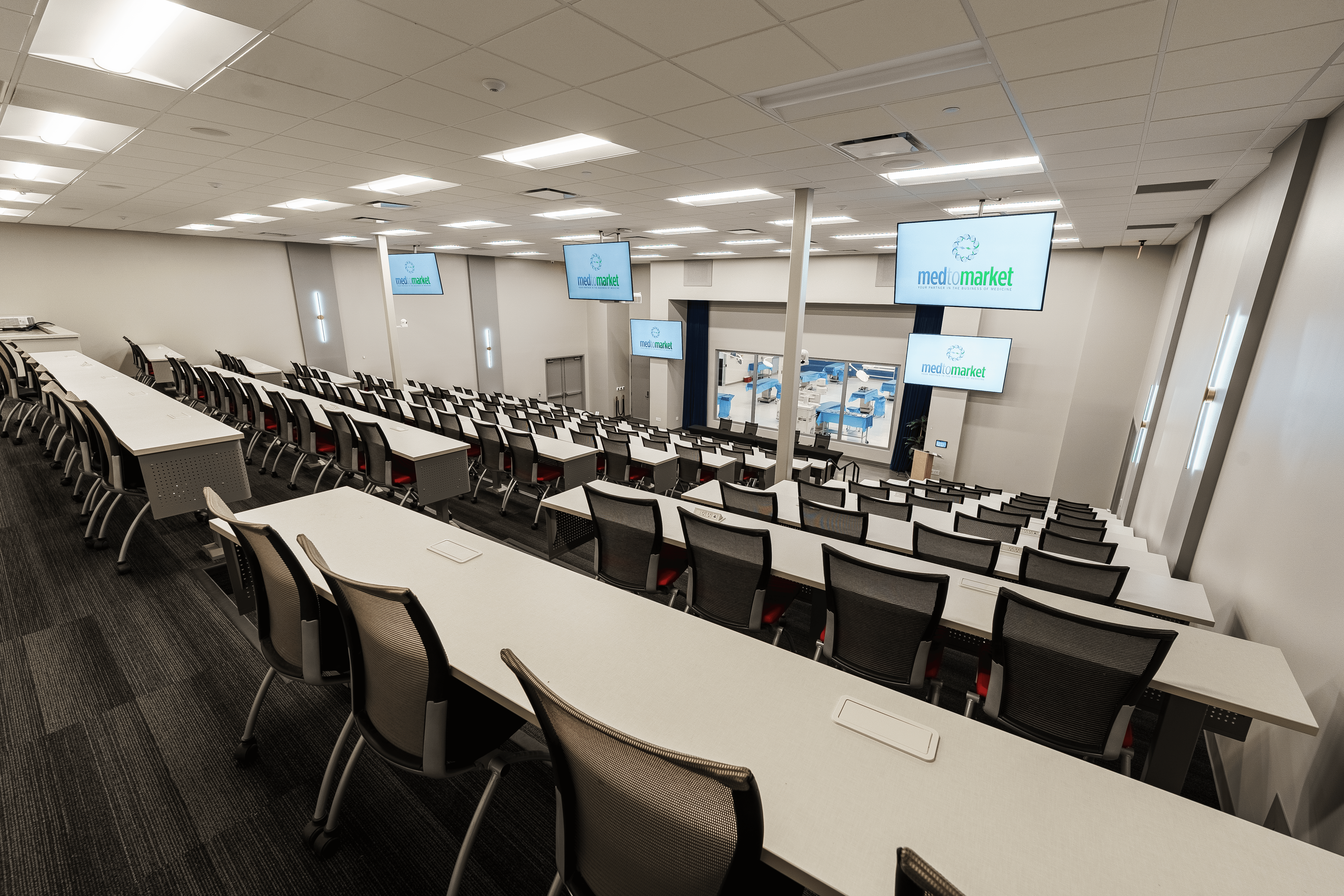 A winding road cuts through rocky terrain, surrounded by patches of green grass and illuminated by sunlight.