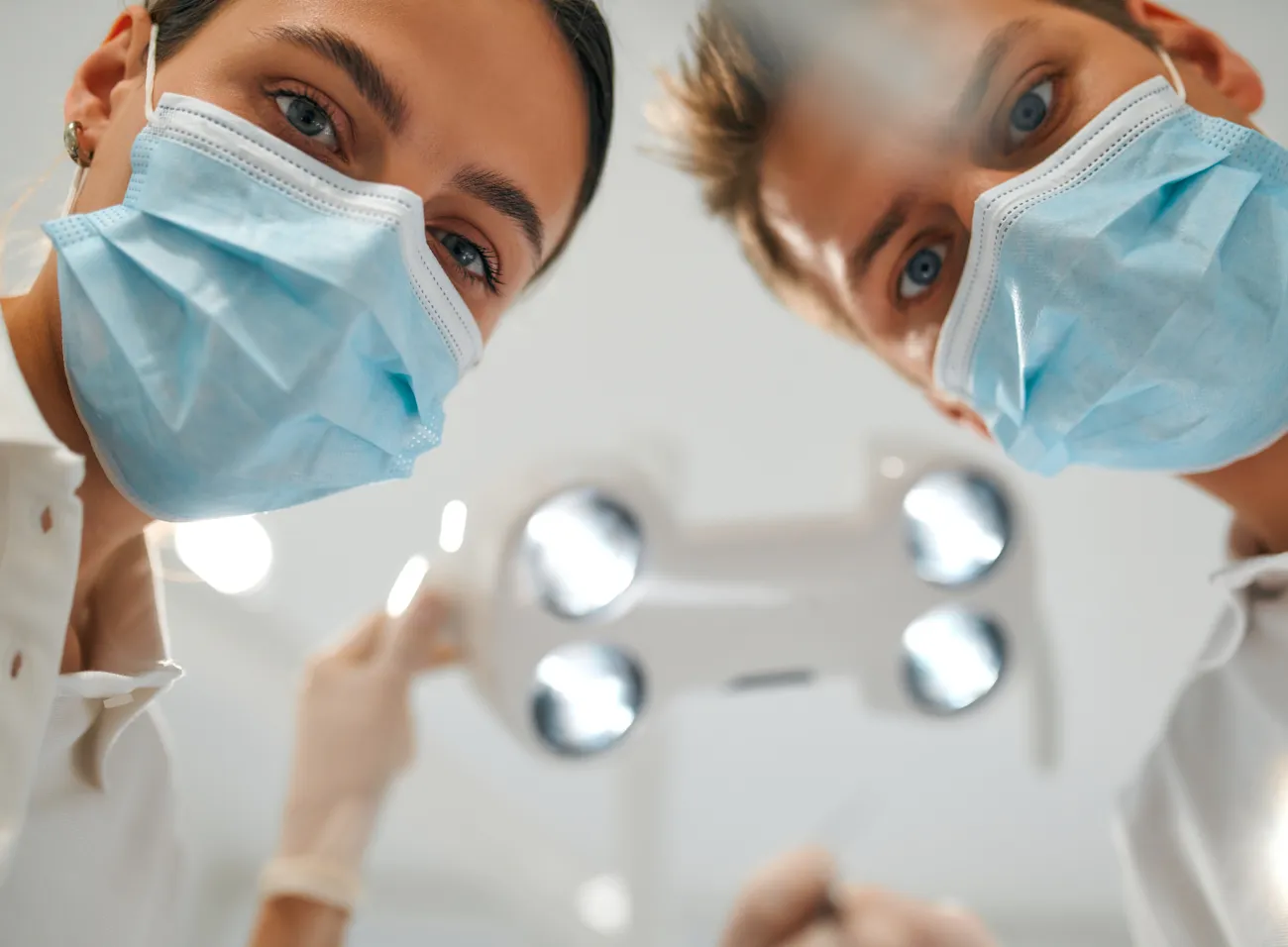 Stomatolodzy pochylający się nad pacjentem.