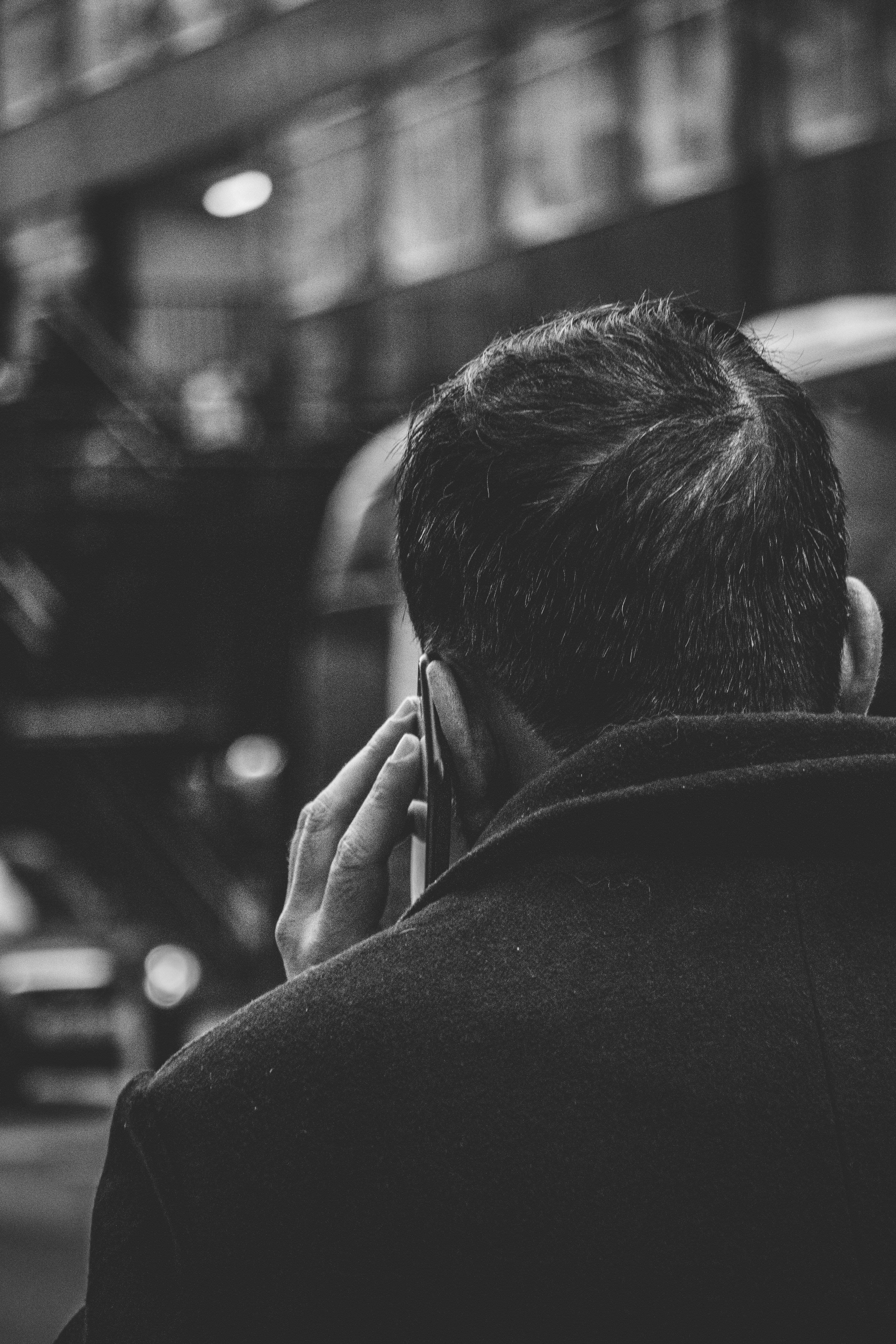 grayscale photo of man using smartphone