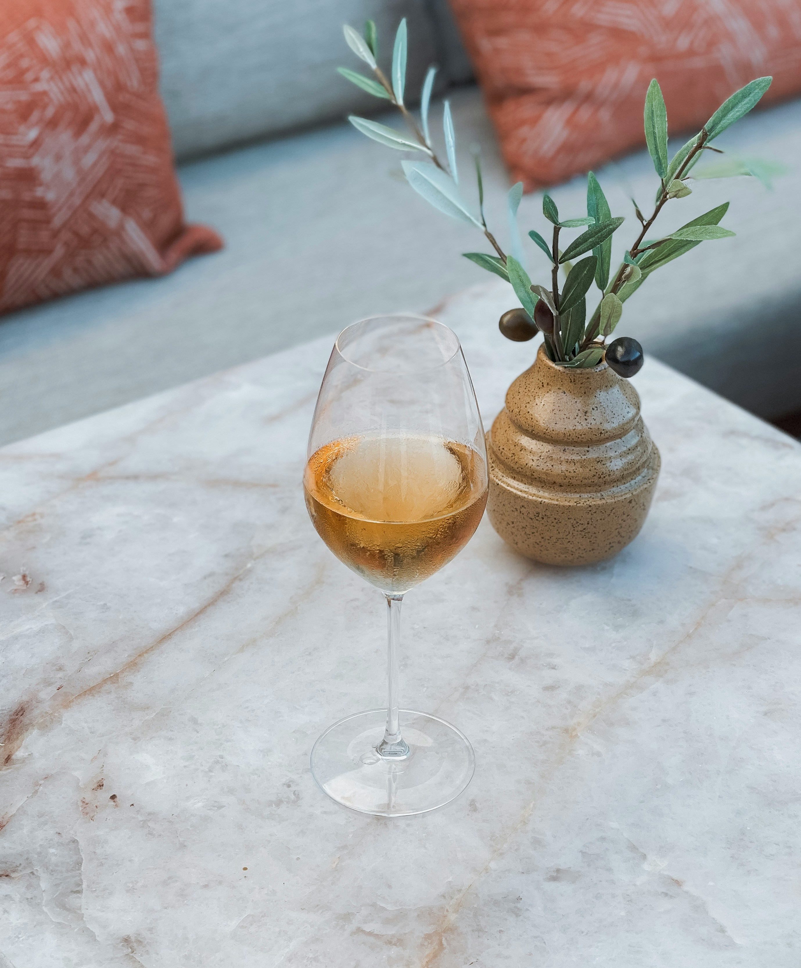 a glass of wine sitting on top of a marble table