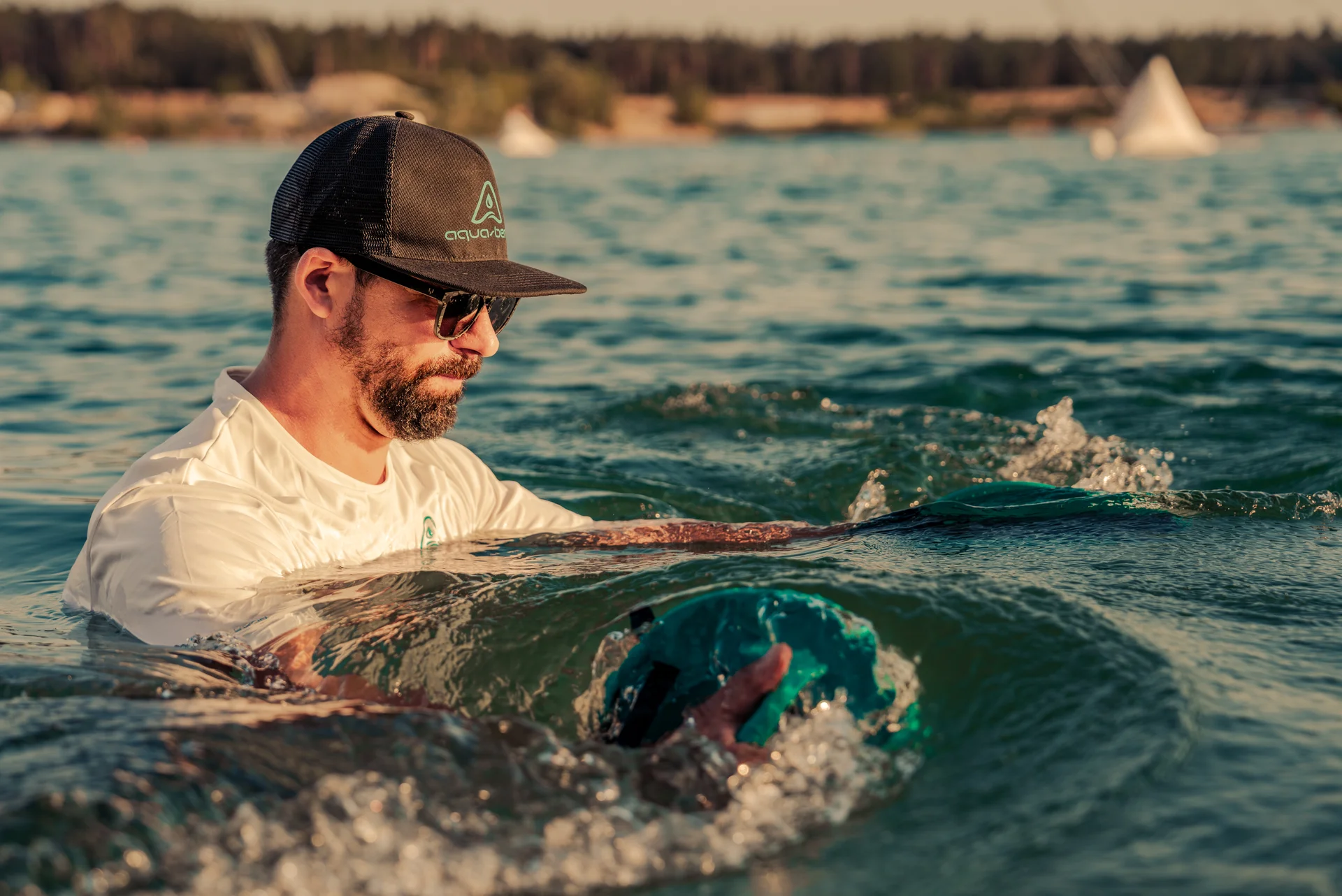Man in the ocean performing a chest butterfly move with two Aqua-Bend discs, bending the water between them