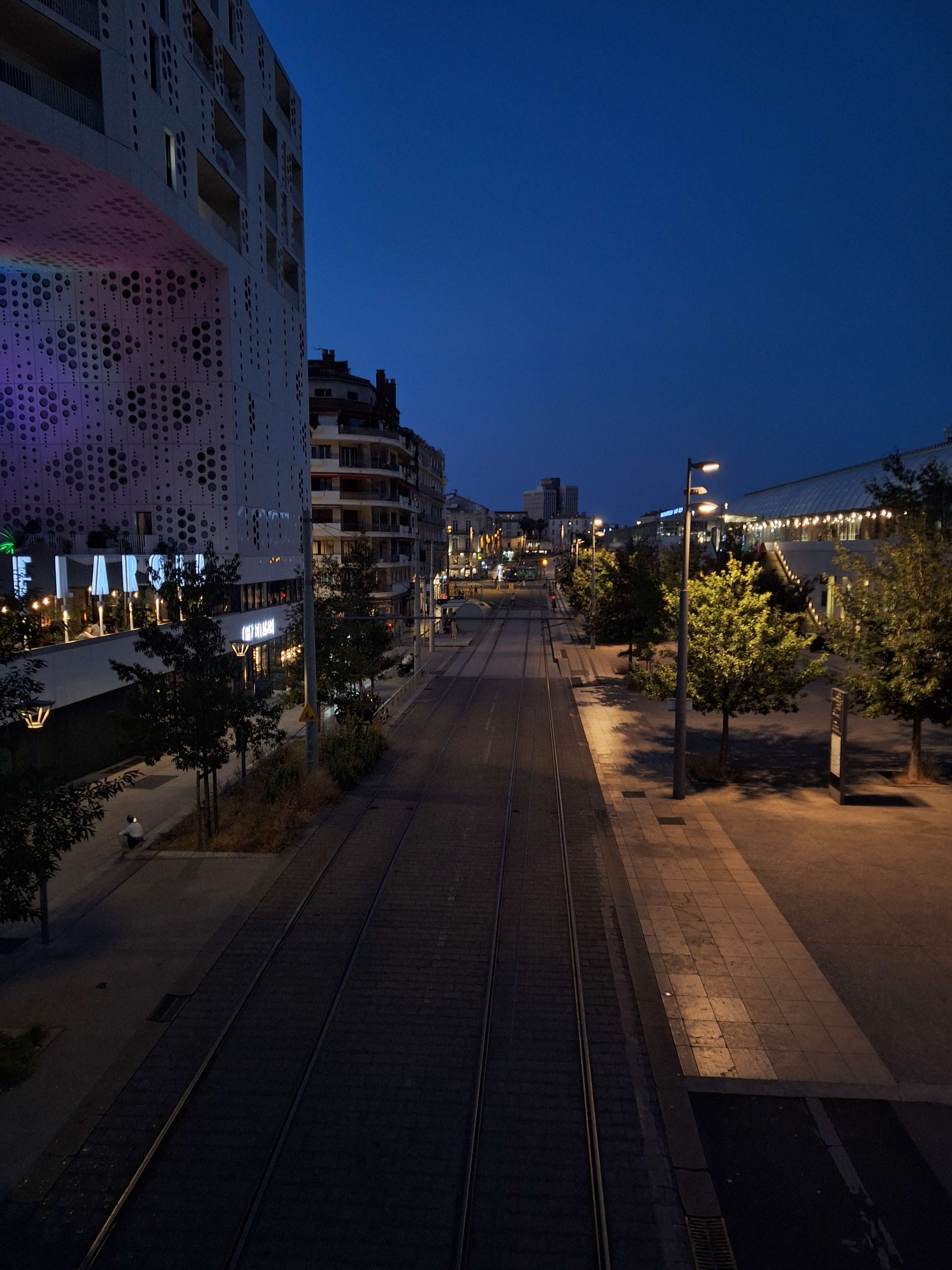 A close-up of a person wearing green-tinted glasses, with a serious expression and smooth skin.