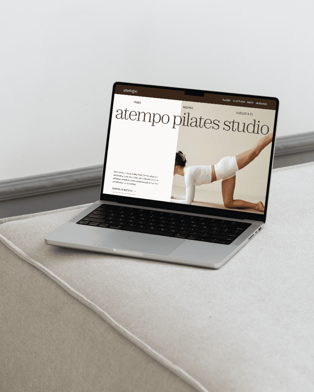 Ordenador sobre un sofa beige con una imagen de una web