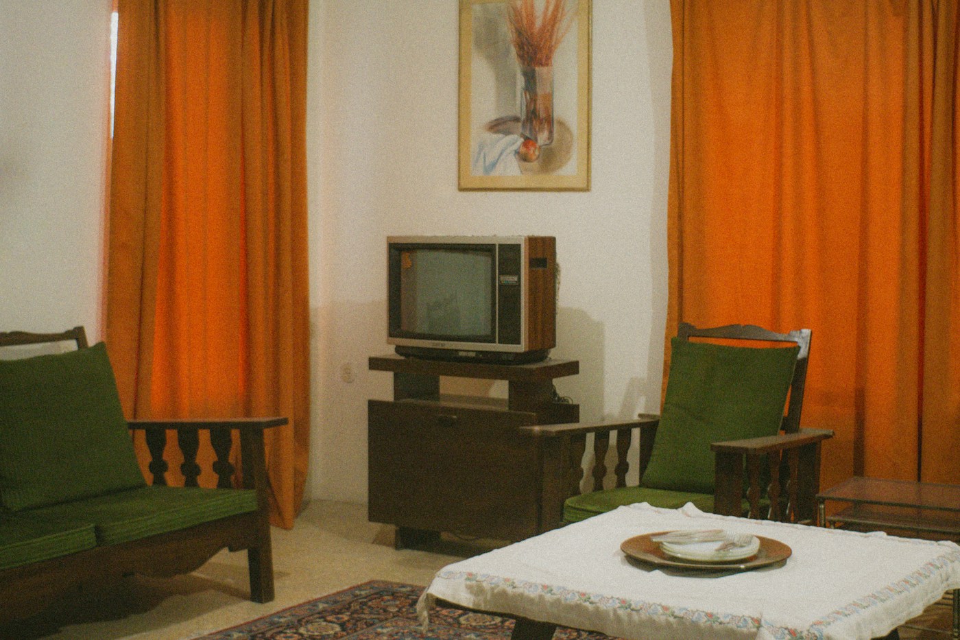 Living room with vintage television and orange curtains