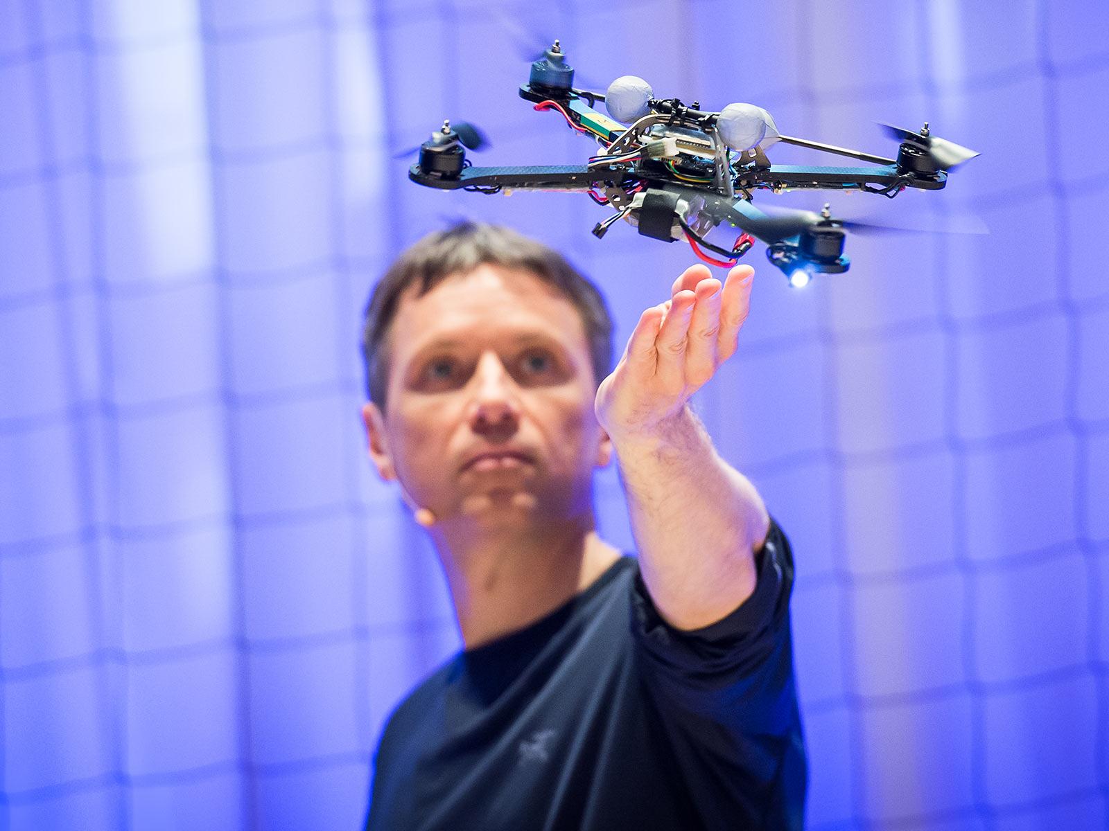 Raffaello D’Andrea demonstrating robotic systems in a modern automated logistics facility.