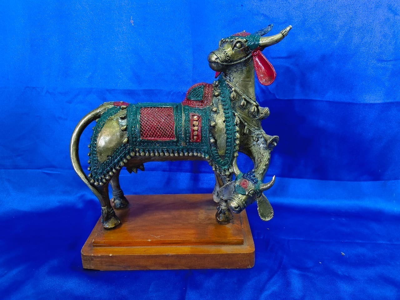 Handcrafted decorative metal cow figurine on wooden base
