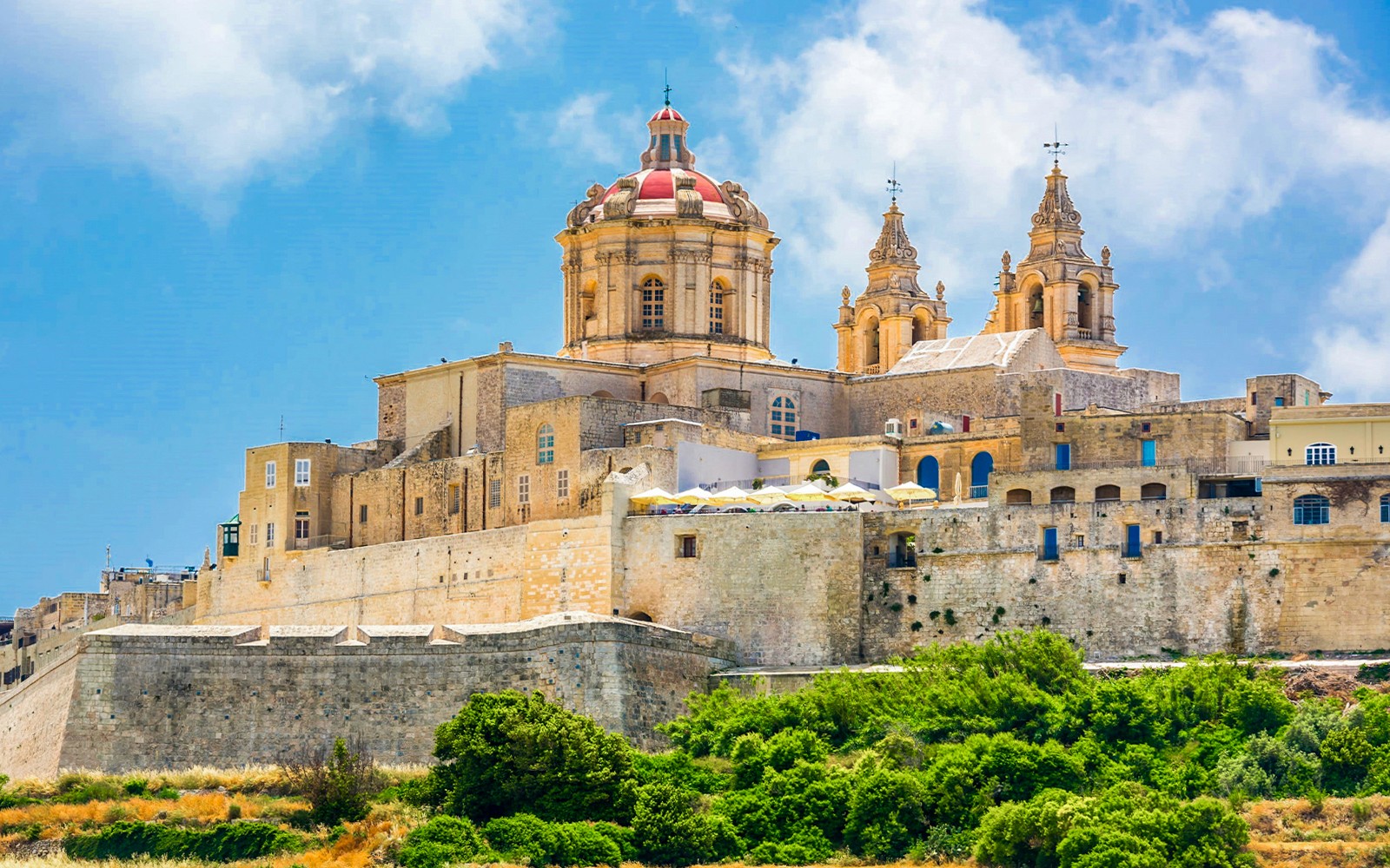 Mdina Cathedral and city walls under blue sky, Malta.