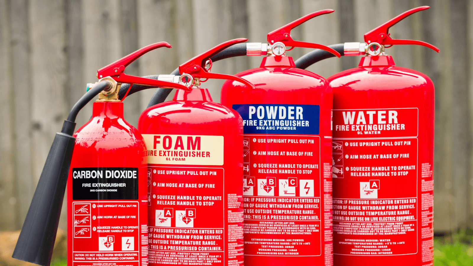 Four fire extinguishers are lined up.