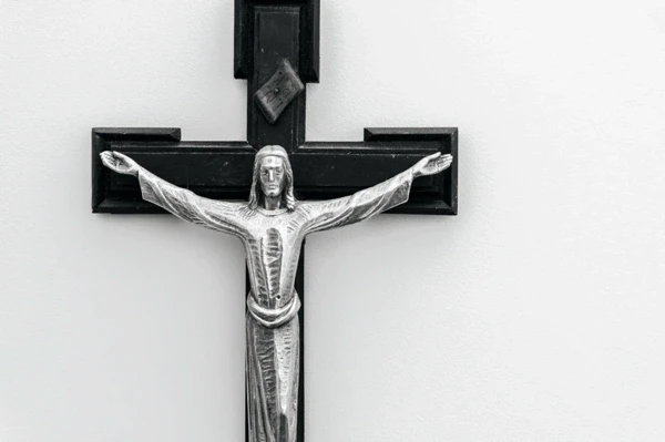 Metal crucifix mounted on a white wall at Our Lady’s Home of Compassion