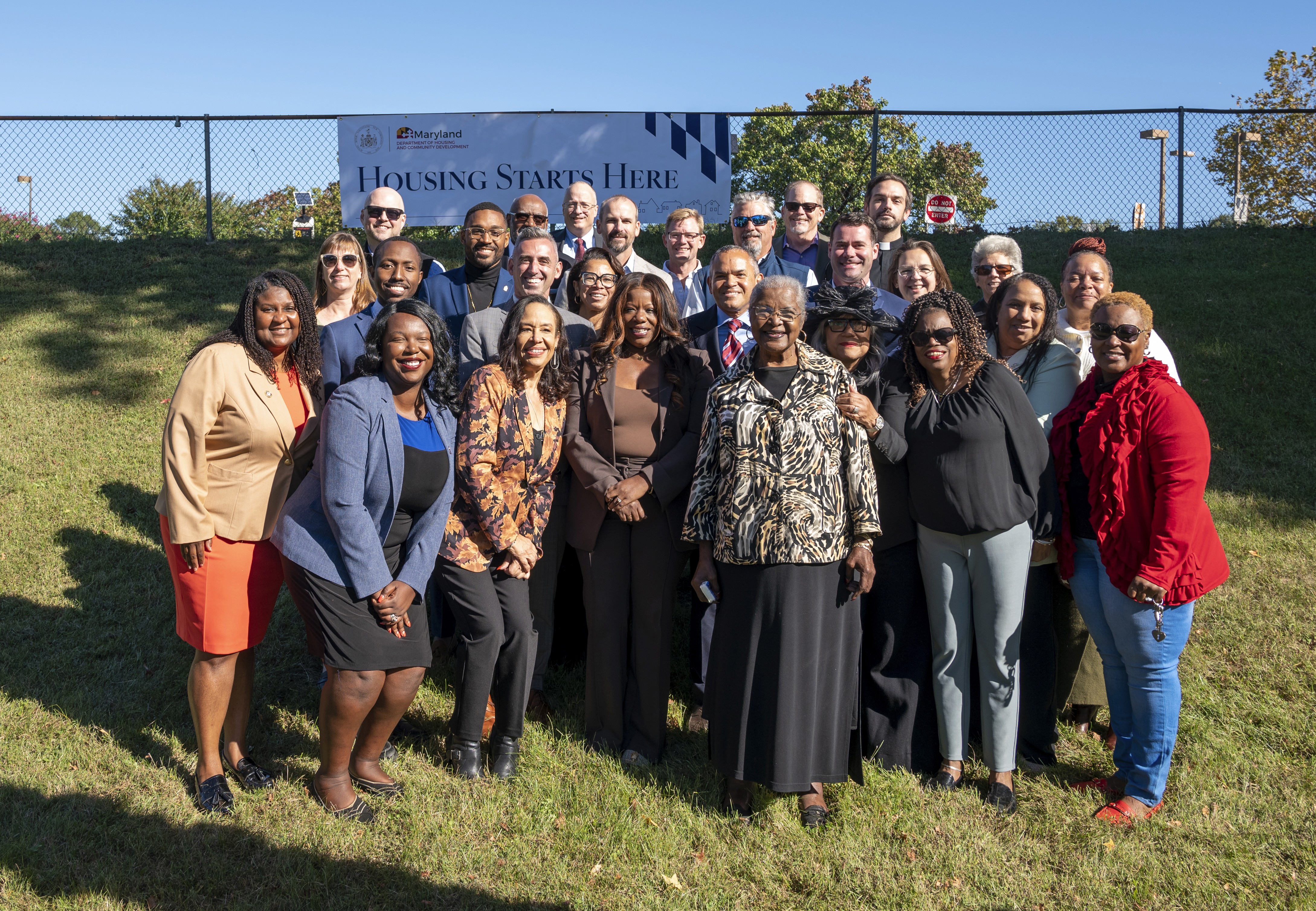 man in gray hoodie and blue denim jeans standing on brown wooden parquet flooring