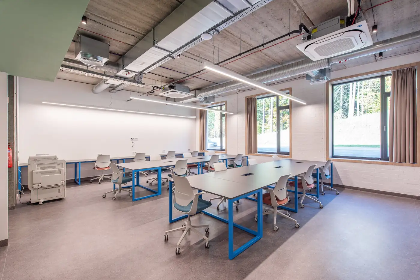 Dedicated study room in Vilnius student accommodation with large tables, chairs and natural daylight.