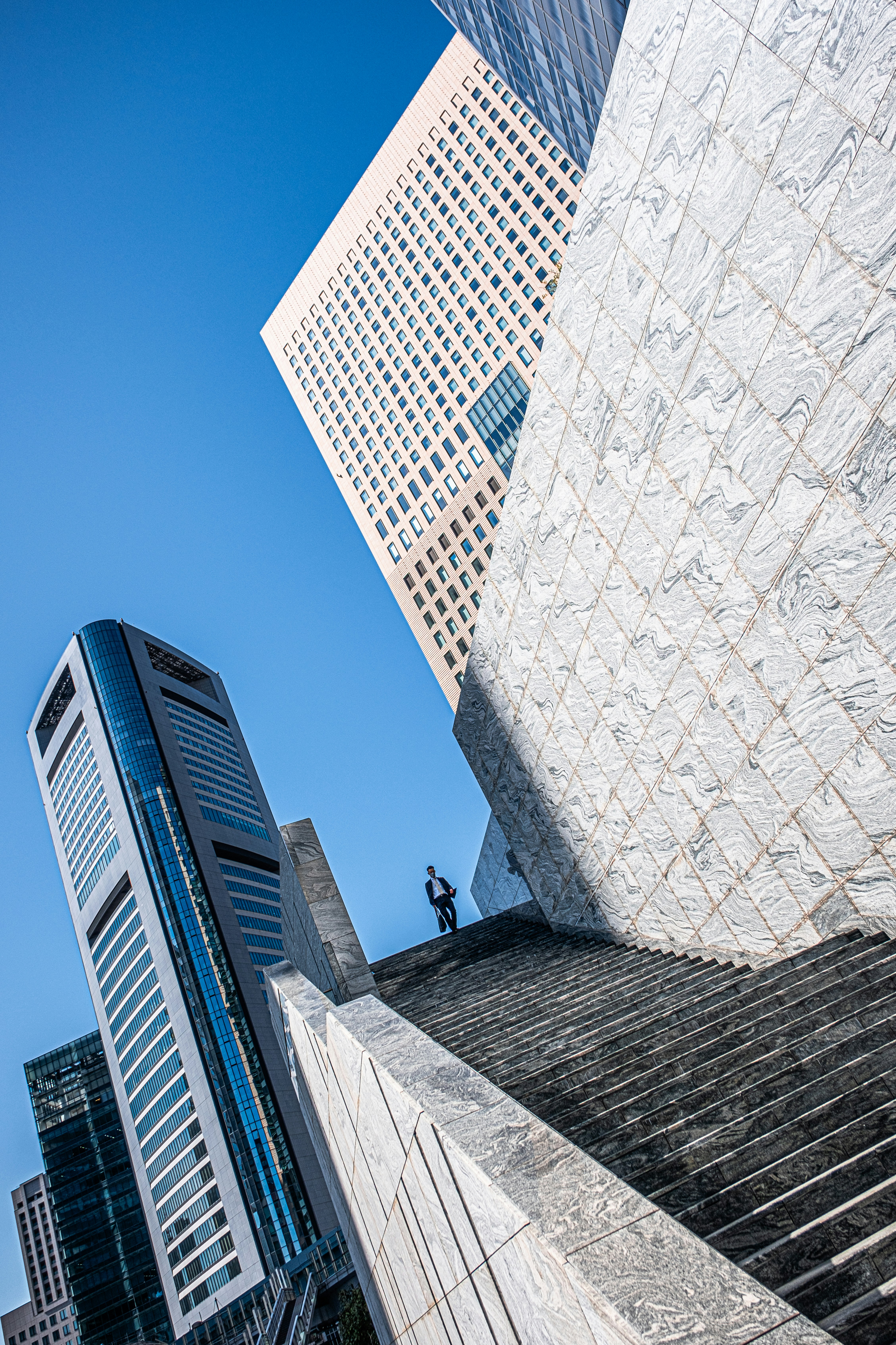 A tall building next to a very tall building