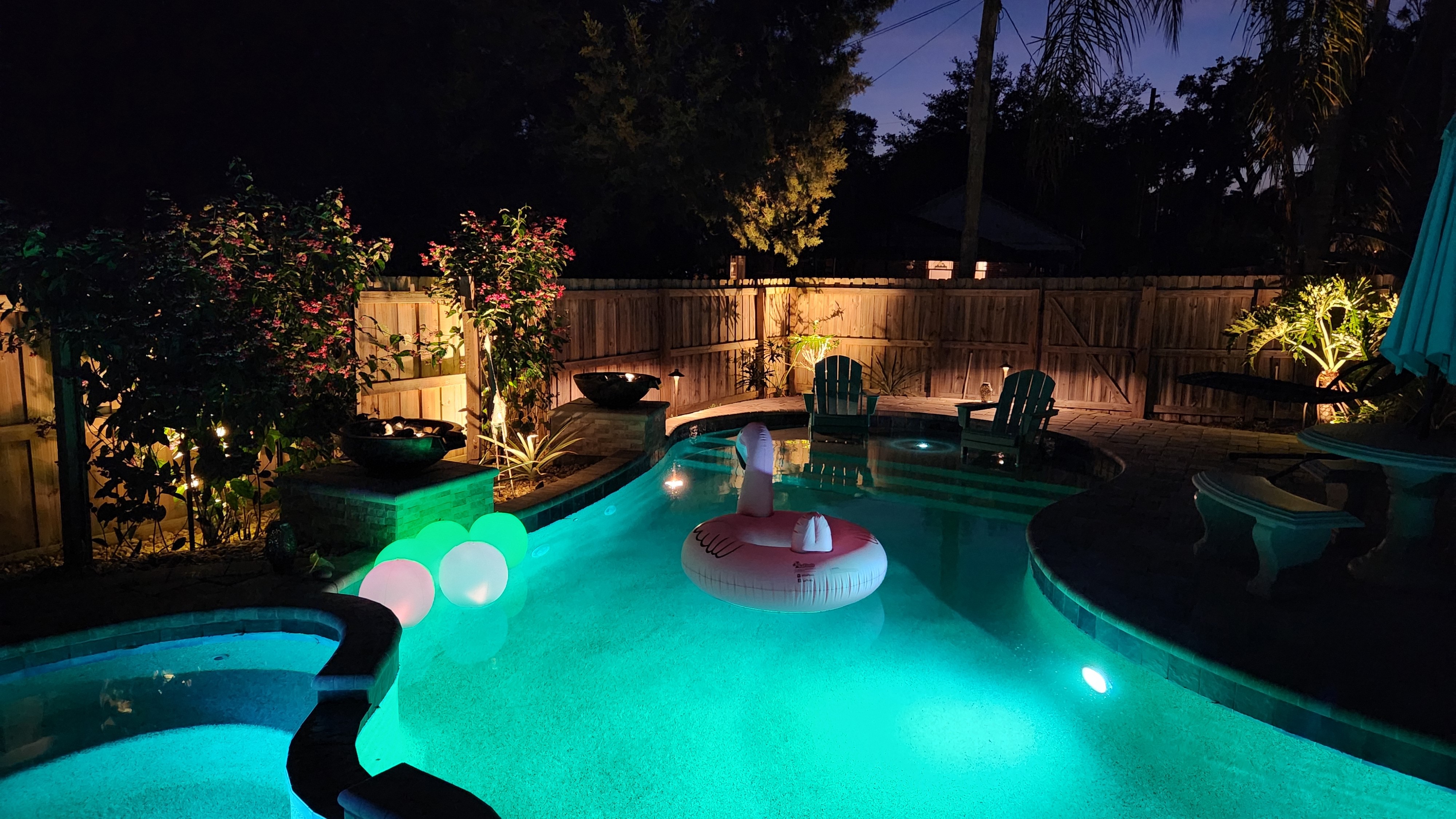Custom outdoor living lighting illuminating a patio entertaining area at night