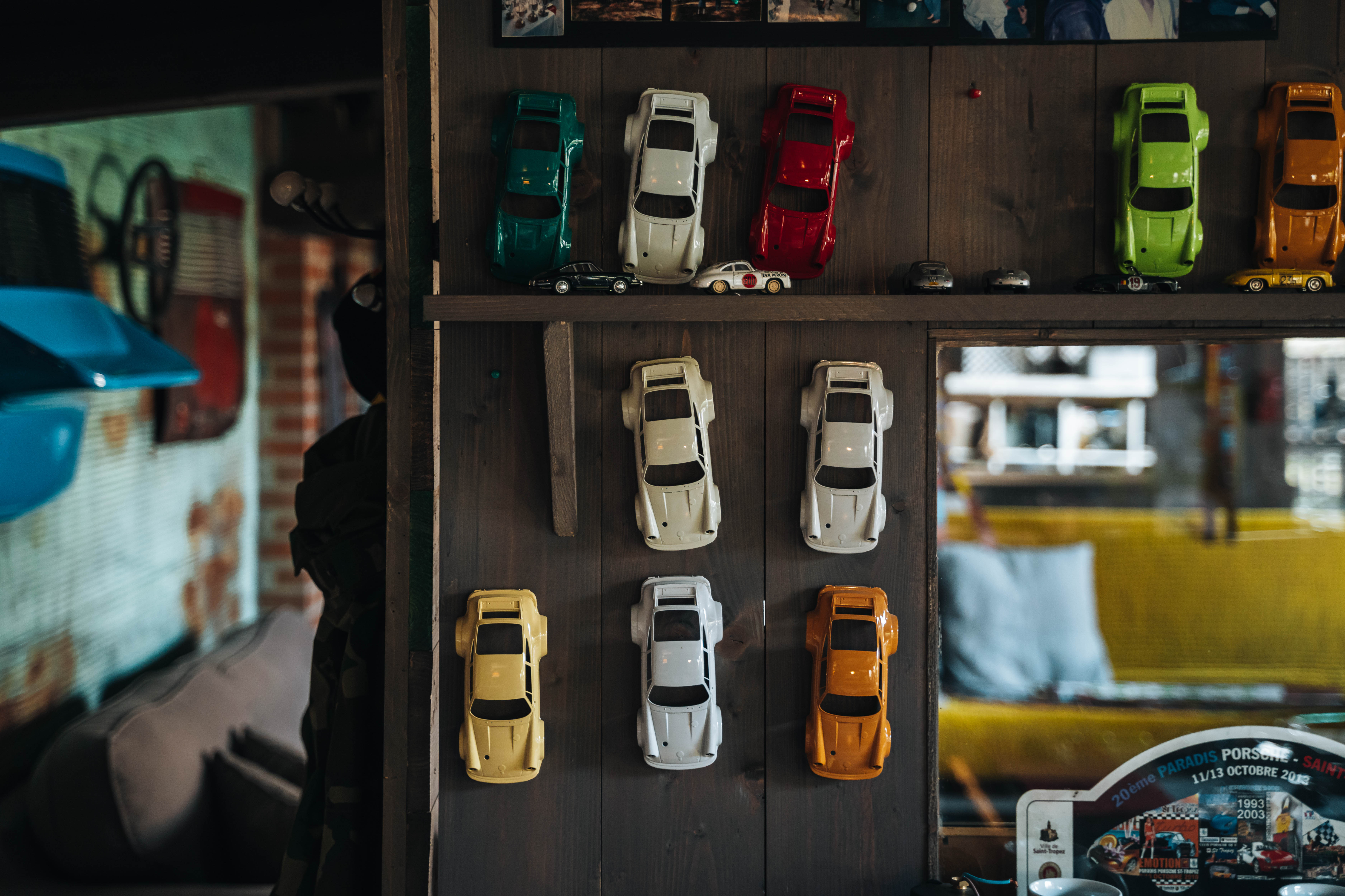 Modellini Porsche Carrera di vari colori su muro in legno