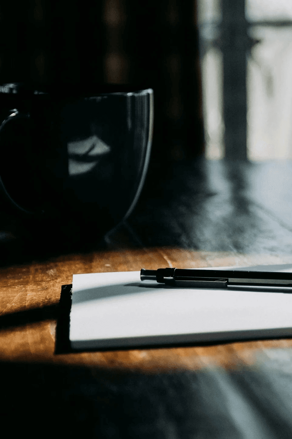 Notizbuch und Kaffeetasse auf Holztisch