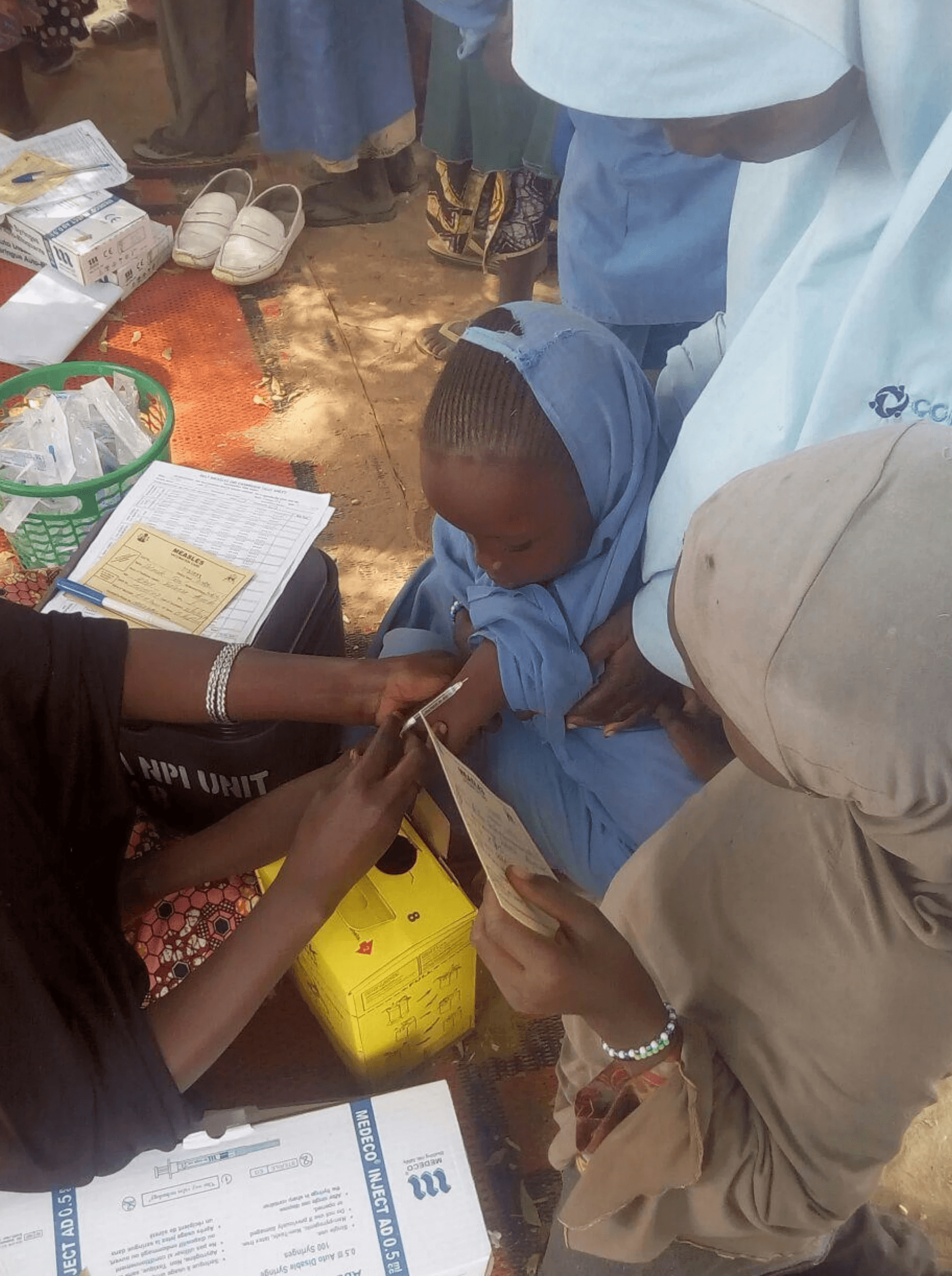 Three children walk along a dirt path.