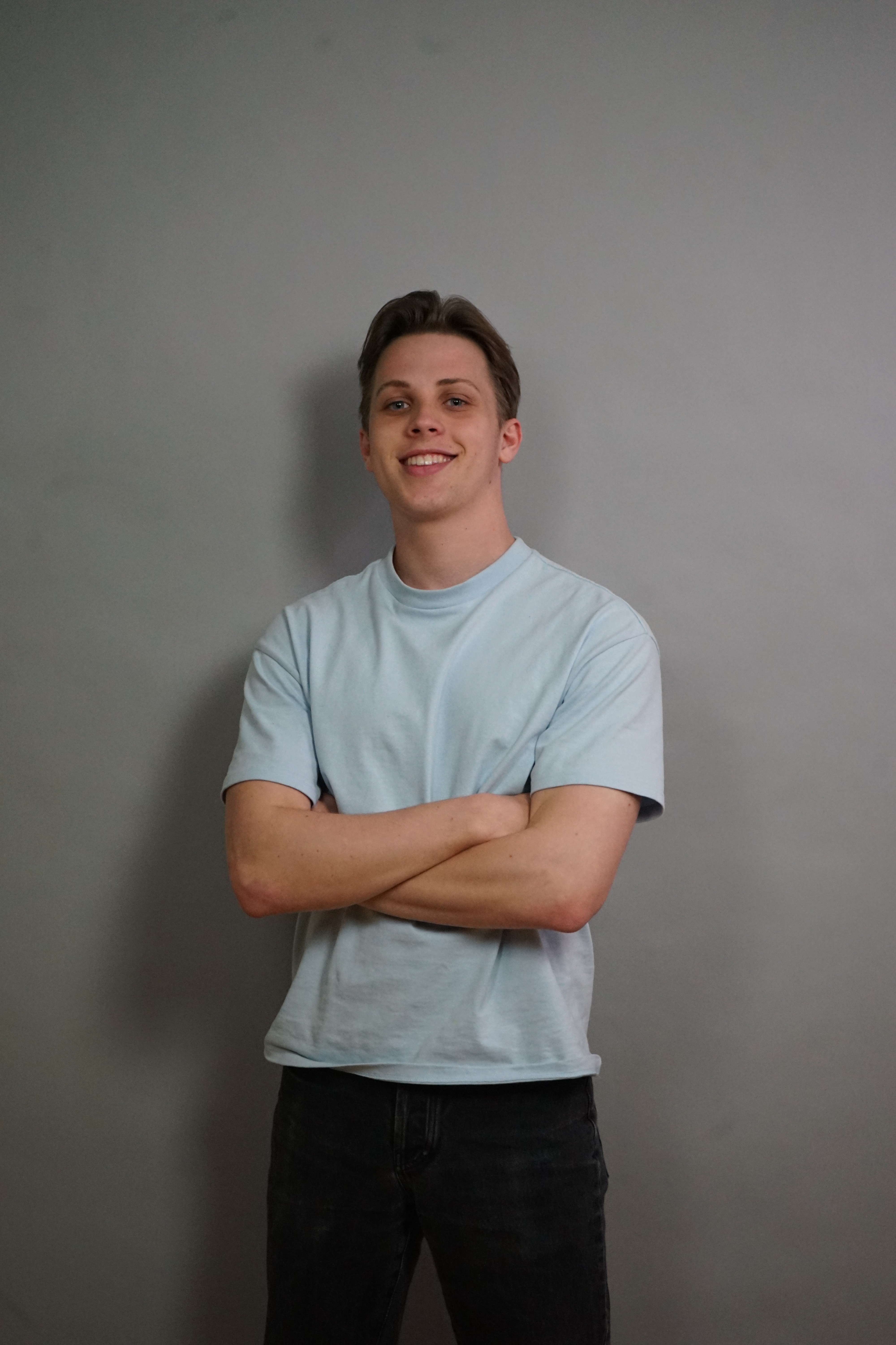 Portrait of a laughing person with curly hair wearing a white shirt