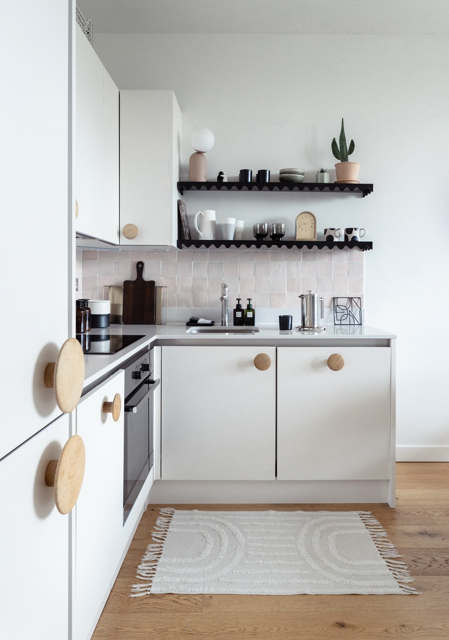 Playful and contemporary kitchen in London new build by Atelier Akuko, featuring cabinetry with oversized door handles for a characterful interior design.