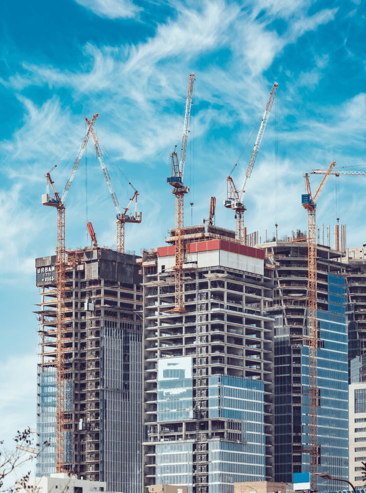 A man and a woman, both in business attire, are engaged in a serious discussion at a table with documents. The setting conveys a professional tone.