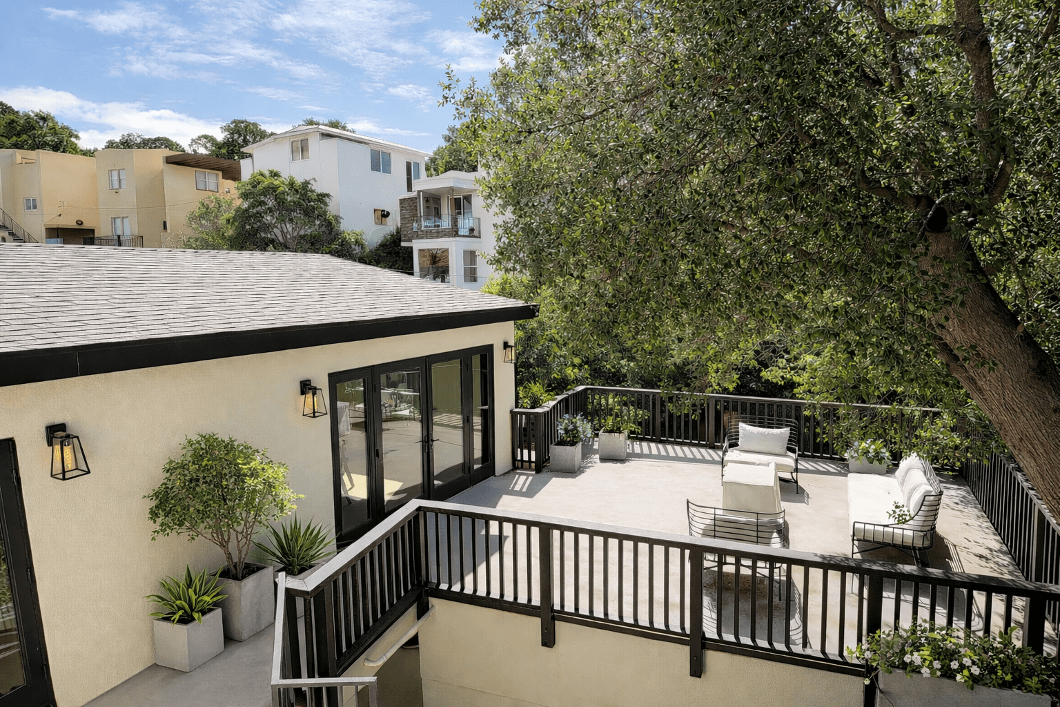 Modern house with elevated glass balcony and hillside view