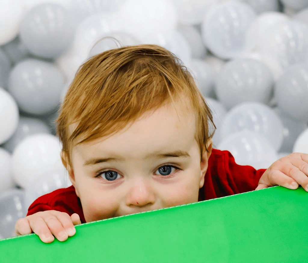 Kid plying in pool ball