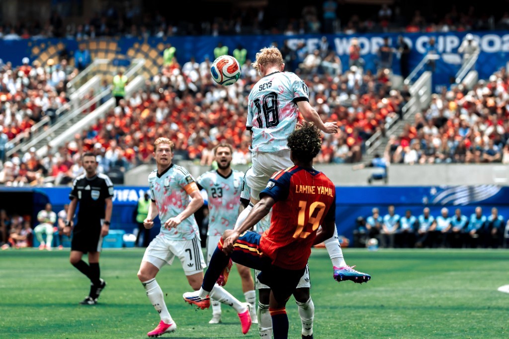 Belgium's Joaquin Seys rises for a header over Spain's Lamine Yamal as Kevin De Bruyne watches during their World Cup quarterfinal