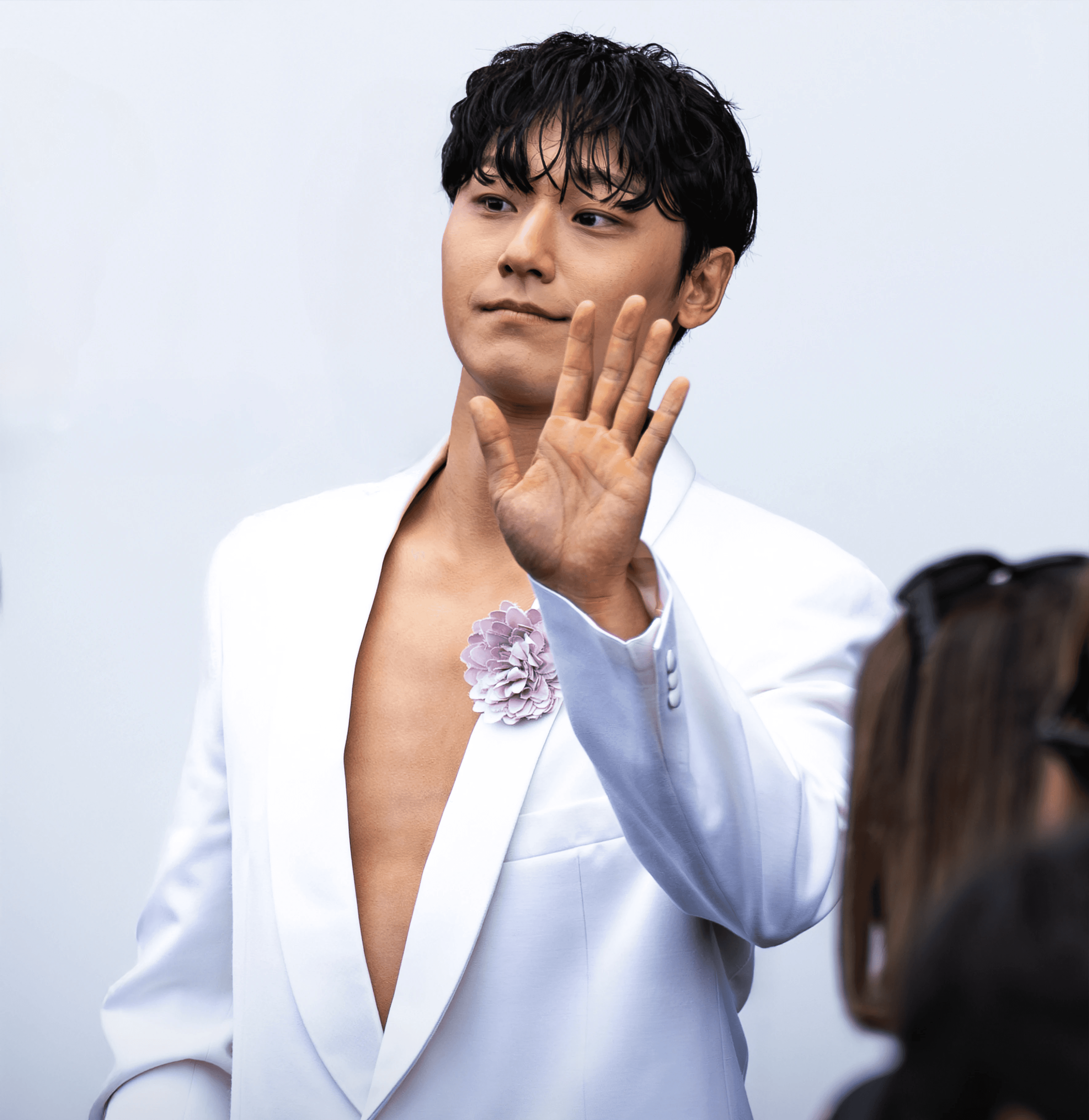 Lee Do-hyun waves to fans at the Prada Men's Spring-Summer 2026 show at Milan Fashion Week.