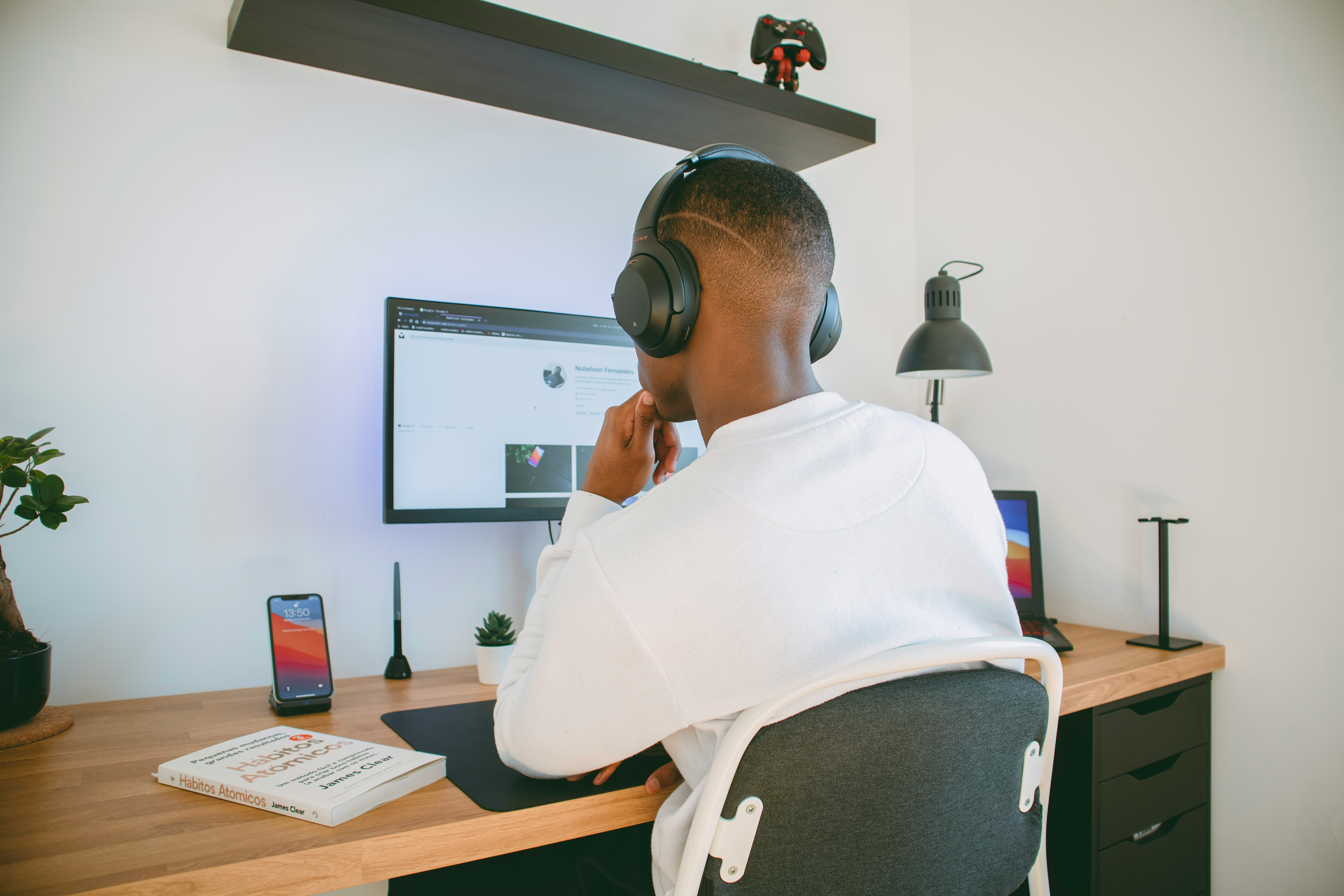A man wearing headphones looking at a computer monitor.