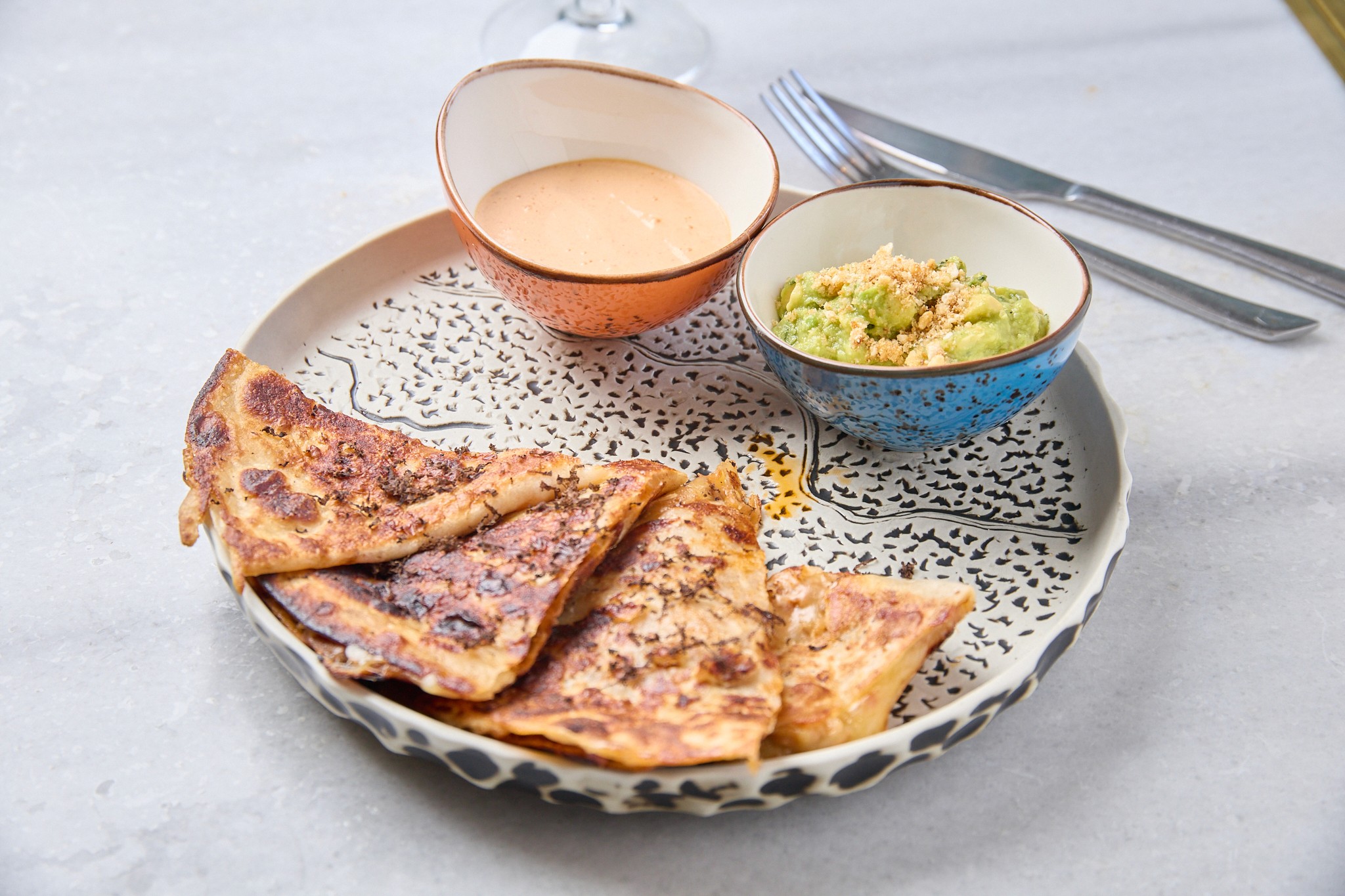 Plato de quesadillas con queso fundido y acompañamiento artesanal en el restaurante Hatillo, Las Rosas (Madrid).