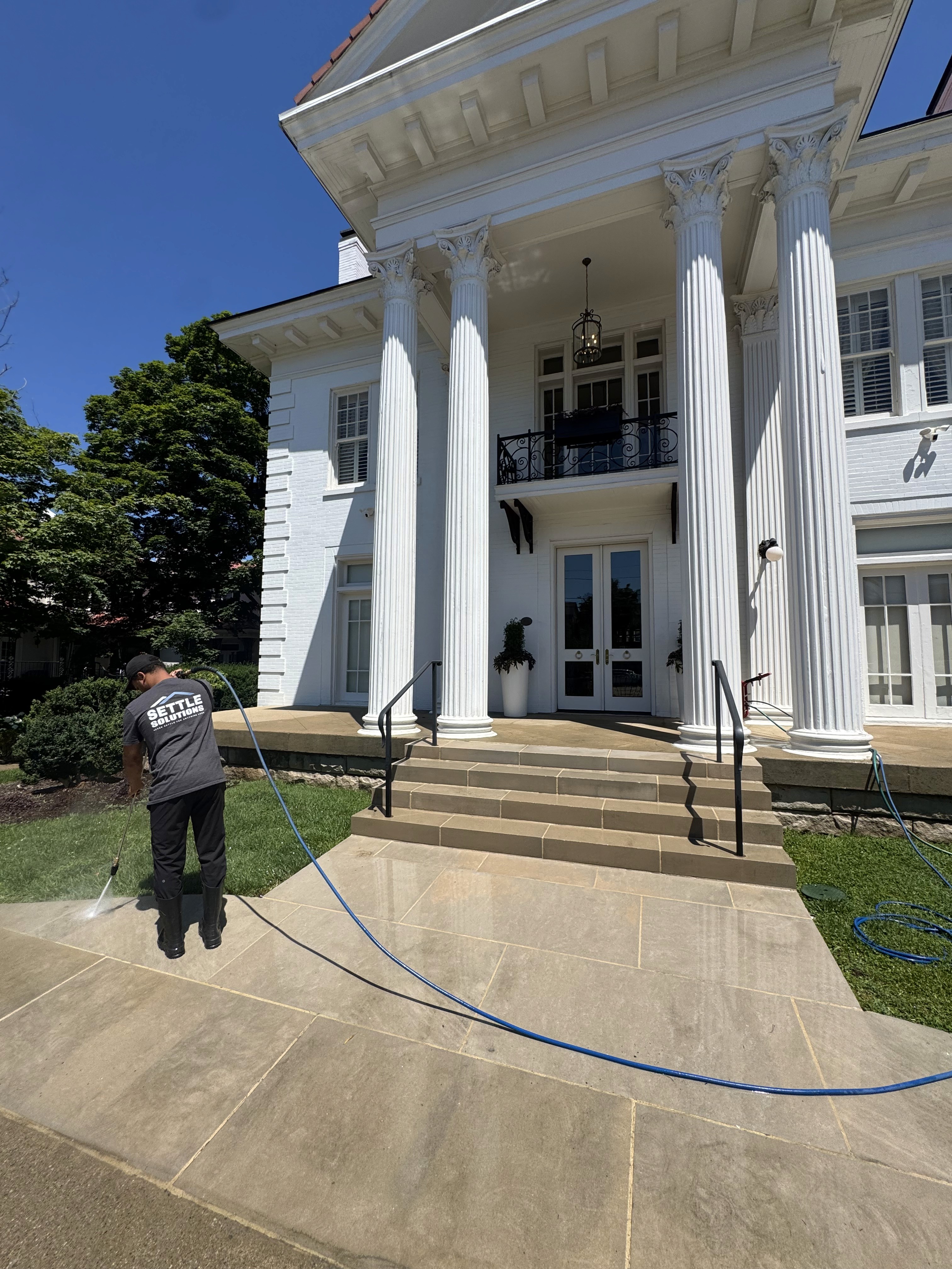 Settle Solutions crew pressure washing driveway