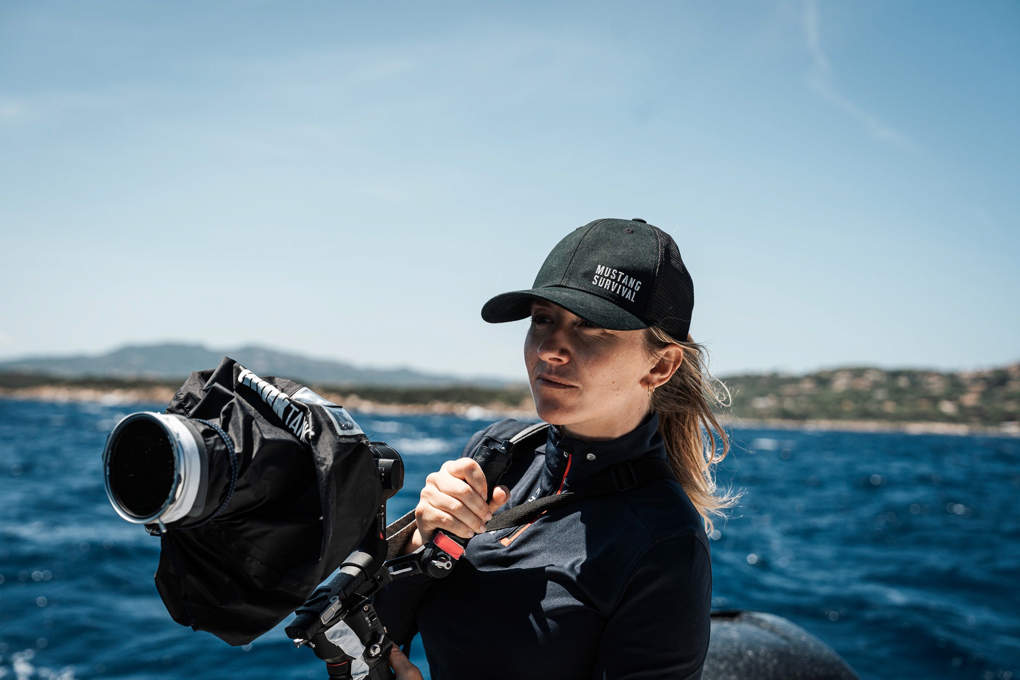 Camera operator carrying a stabilized cinema rig at sea