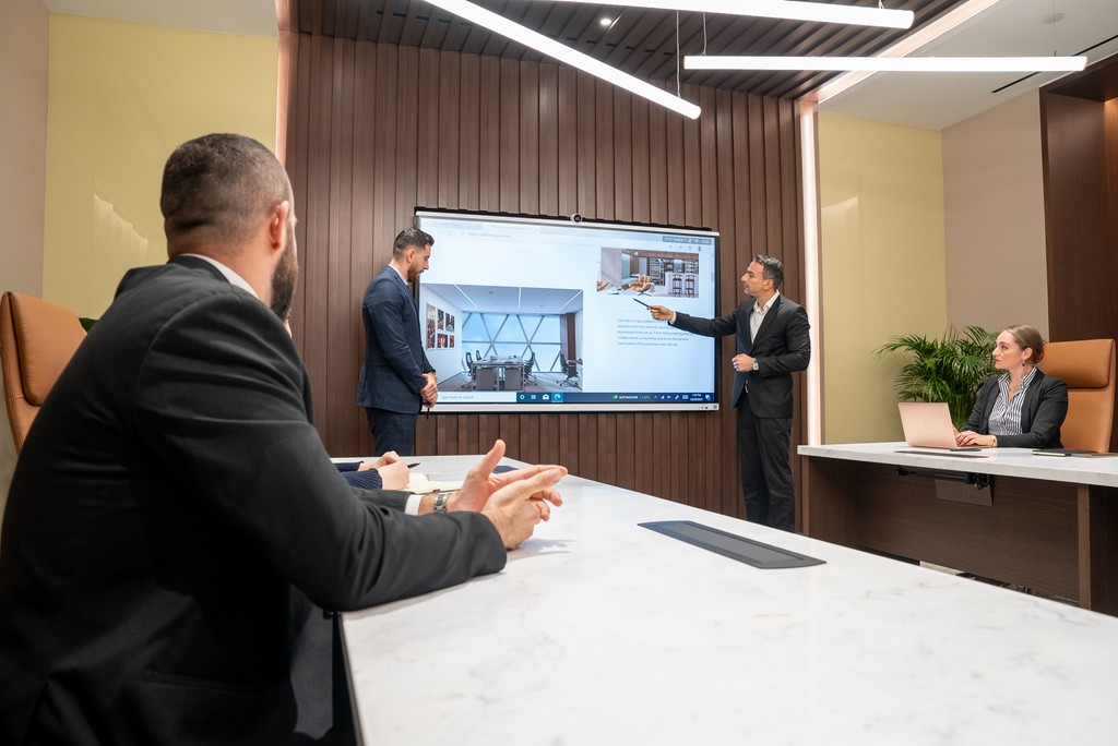 Business meeting taking place in a modern boardroom off Office Square in Aldar HQ.