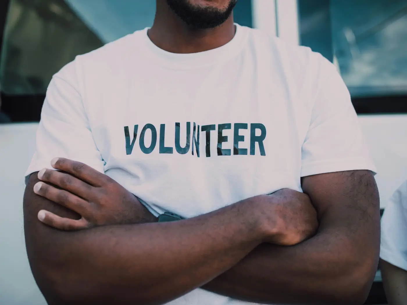 Man wearing a t-shirt with the word 'VOLUNTEER' highlighted, symbolizing volunteer work and solidarity.