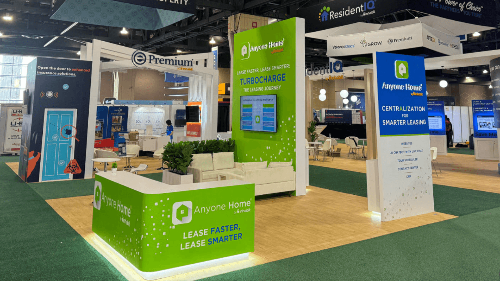 Anyone Home NAA Apartmentalize 2024 20x20 booth at Pennsylvania Convention Center Philadelphia – green demo tower, lounge seating, and open sightlines for leasing tech demos
