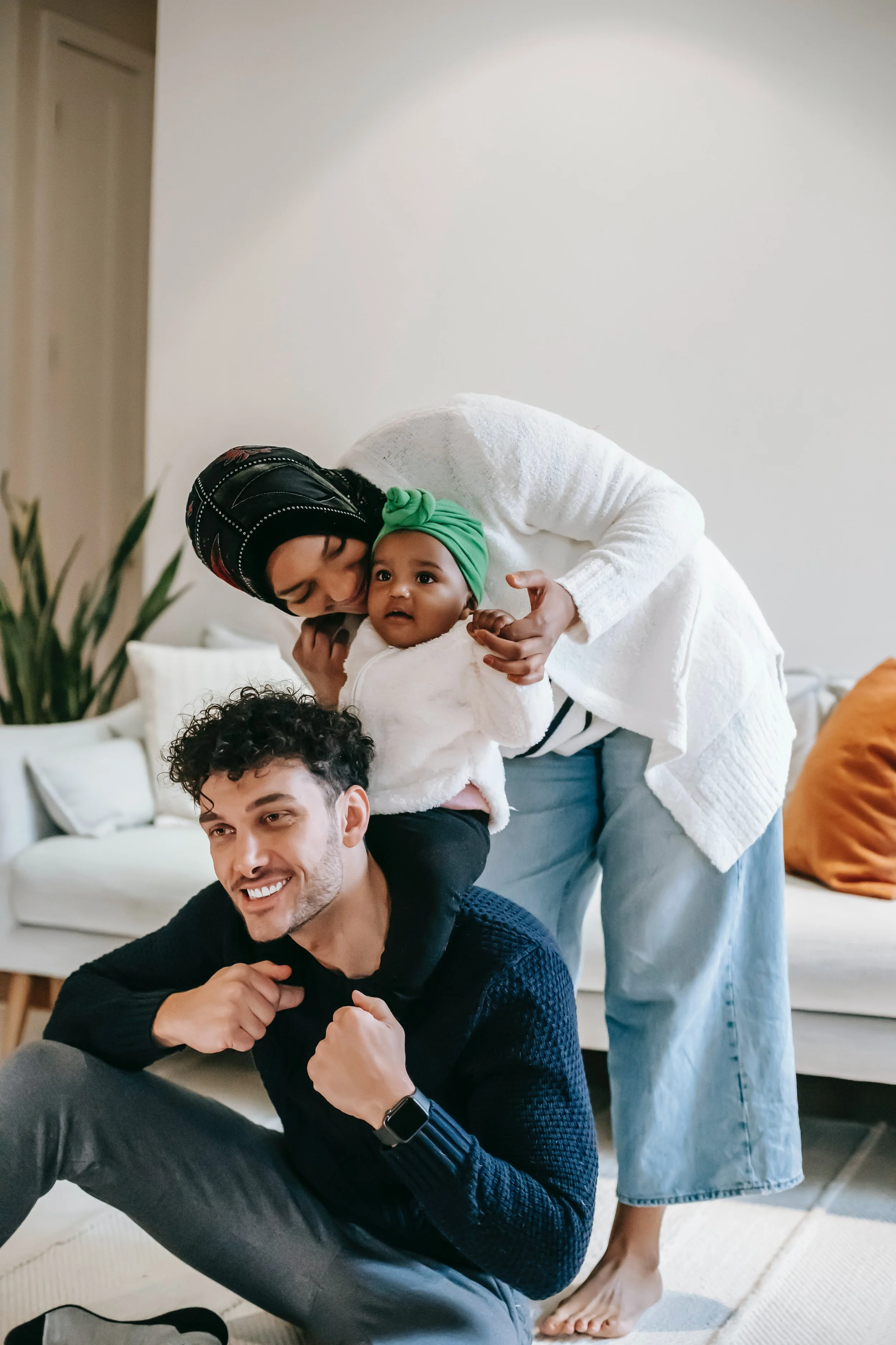 An Asian Muslim couple plays with their toddler-aged daughter