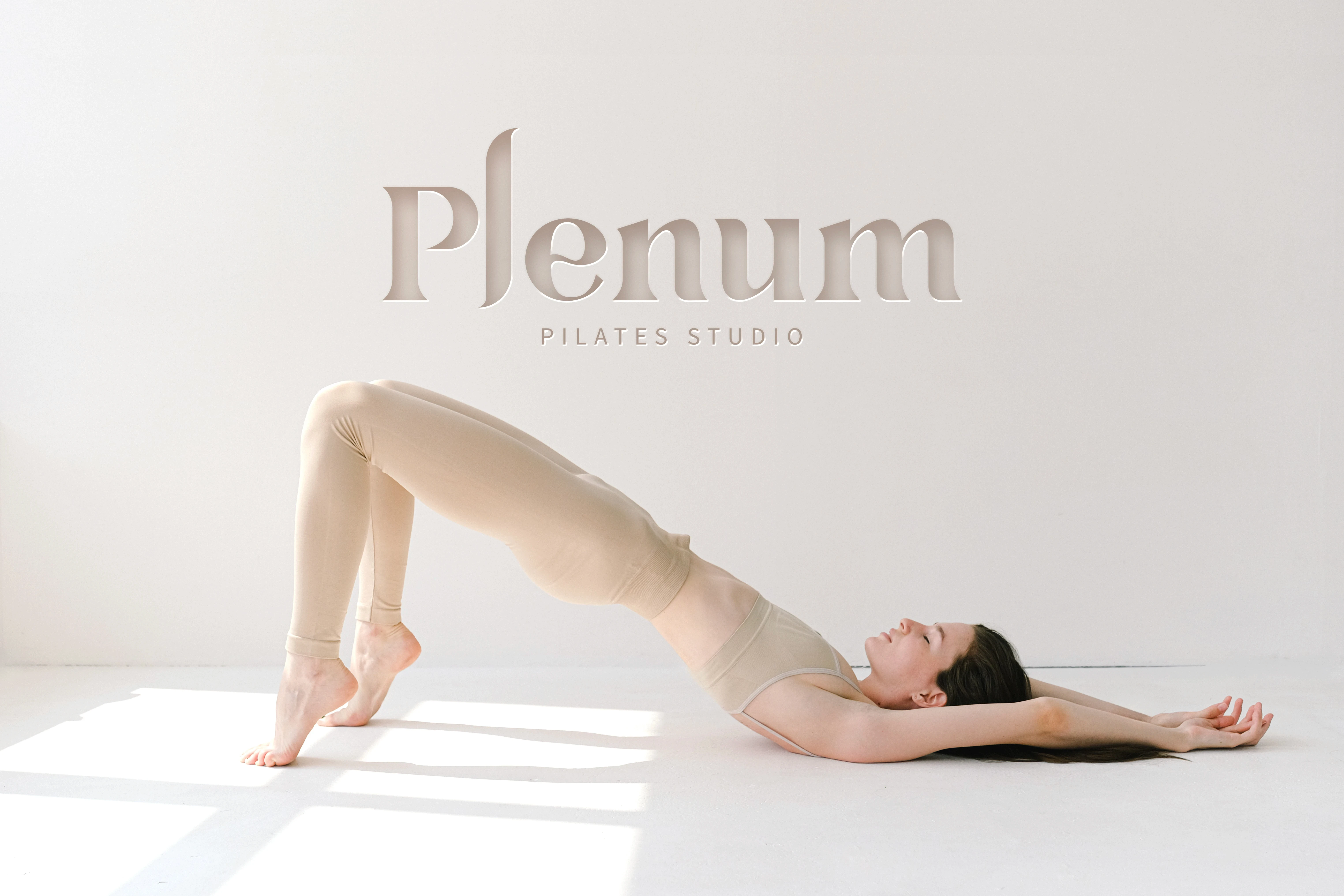 Plenum Pilates Studio logo and brand identity in a minimalist Pilates studio with a woman performing a bridge exercise, representing wellness, movement and contemporary fitness branding in Lisbon.