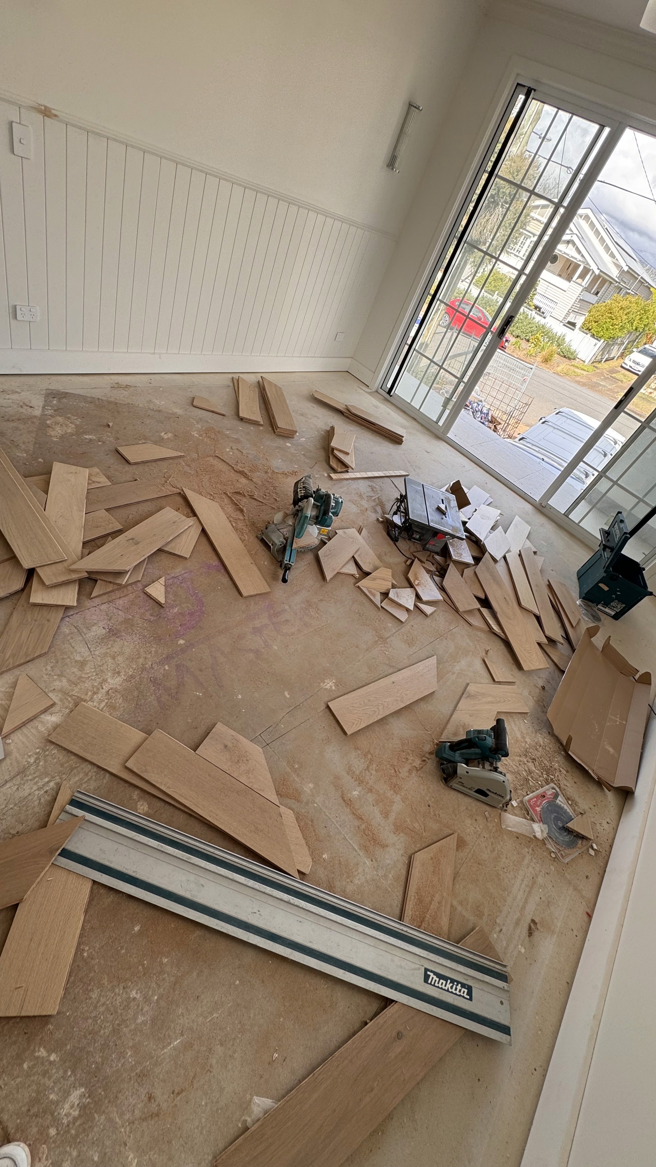 Unfinished room during flooring installation, highlighting the messy renovation stage before a clean, level finished floor.