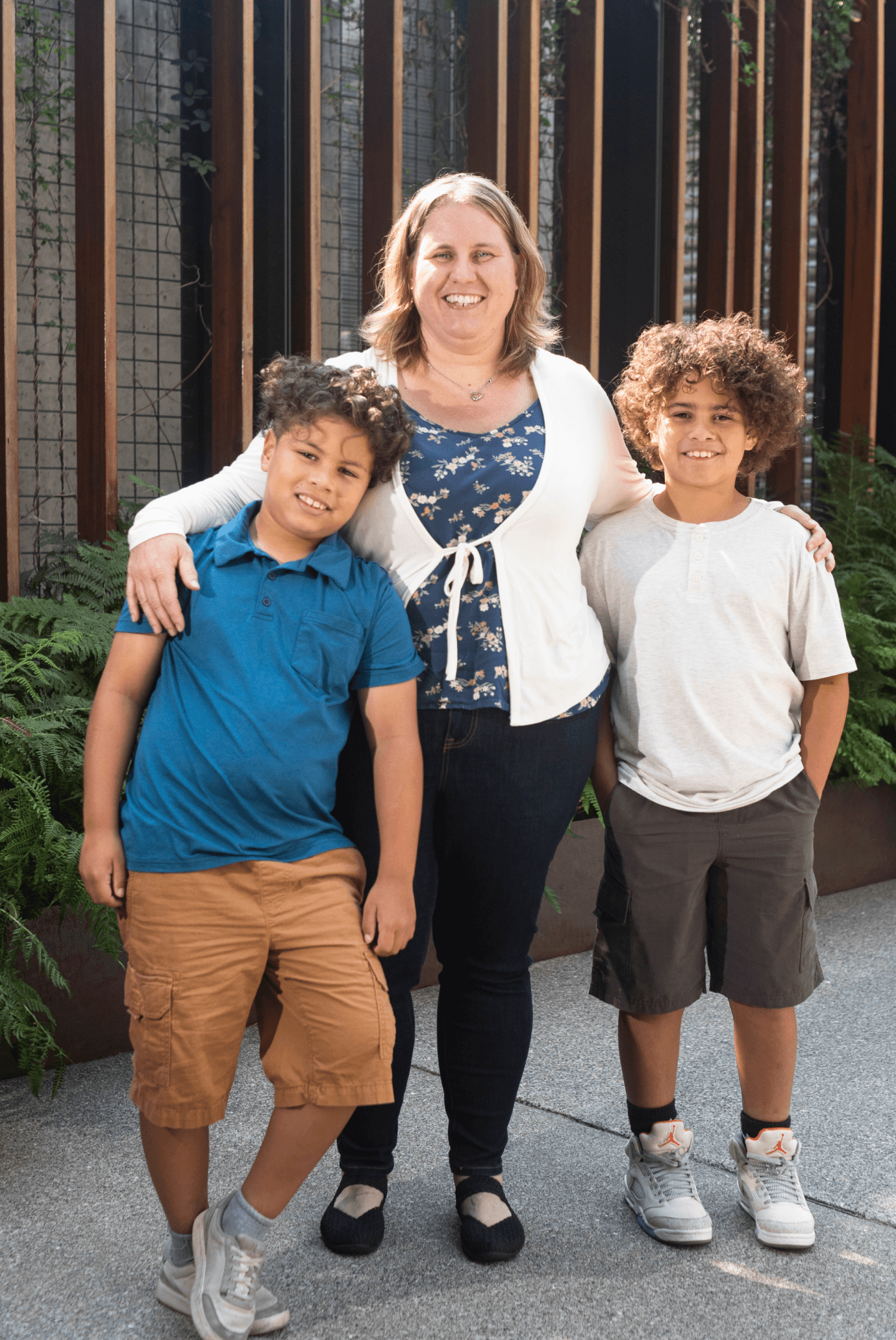 Possible member with her two sons smiling and looking at the camera.