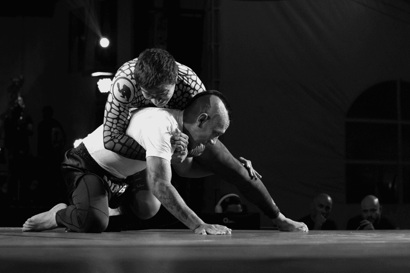 Two wrestlers with one wrestler on top position and another in bottom defense