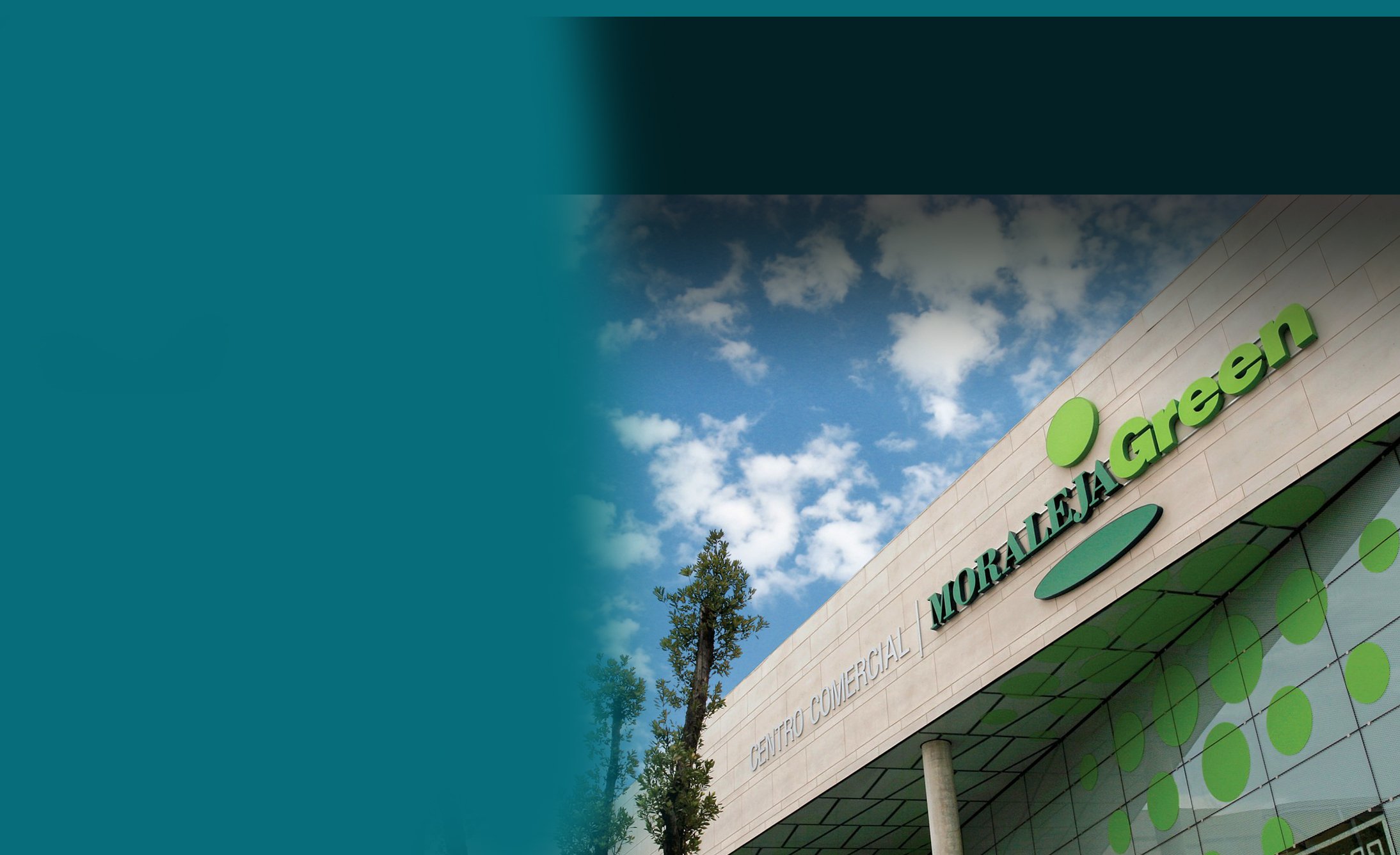 Modern shopping center facade with "Moraleja Green" signage and logo under a partly cloudy blue sky, creating a vibrant and inviting atmosphere.