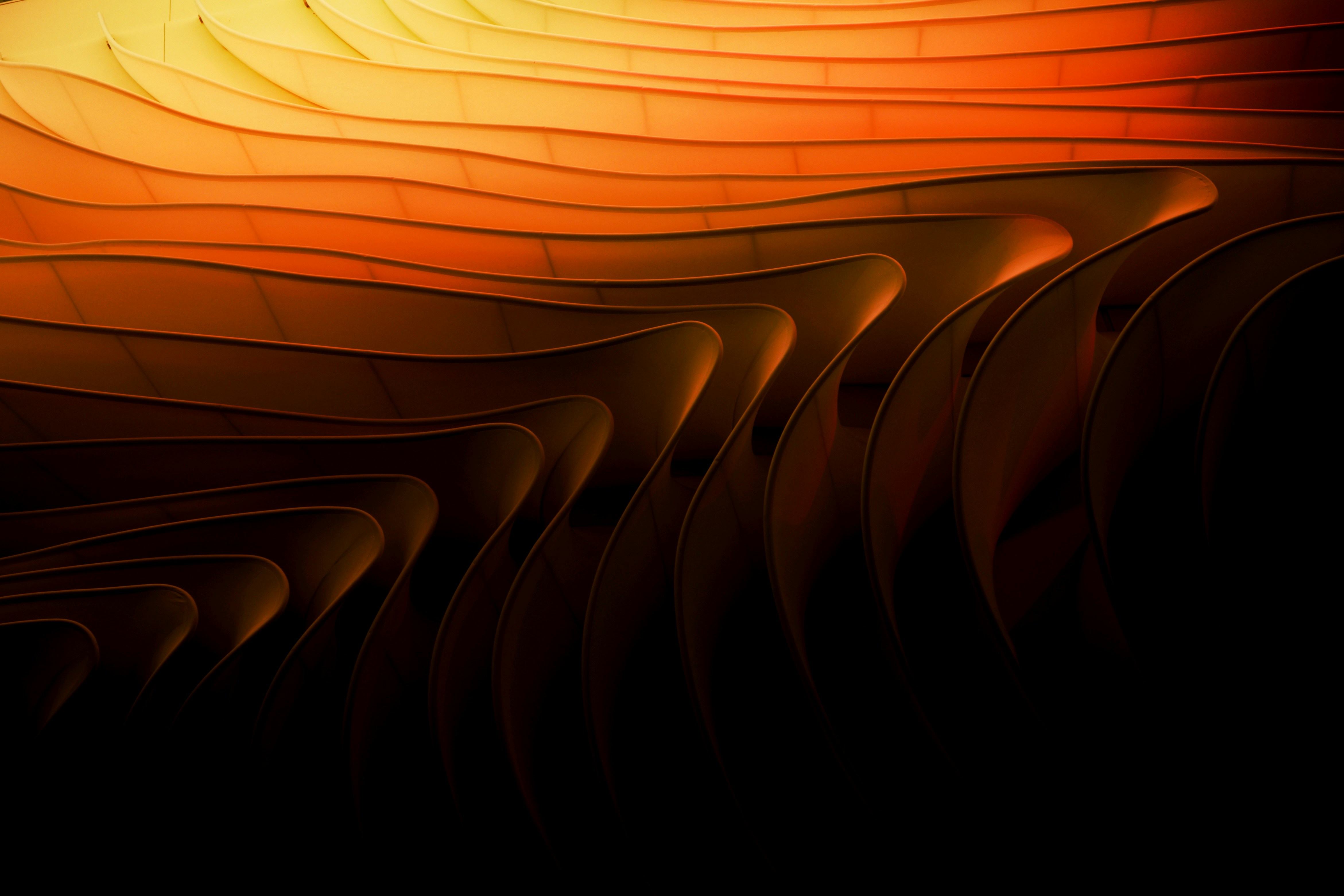 Abstract image of warm orange and black tones, suggesting movement with flowing lines and a sense of depth.