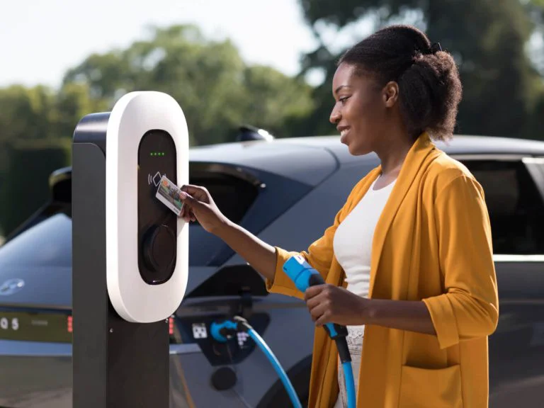 femme qui recharge son véhicule électrique sur une borne de recharge en leasing
