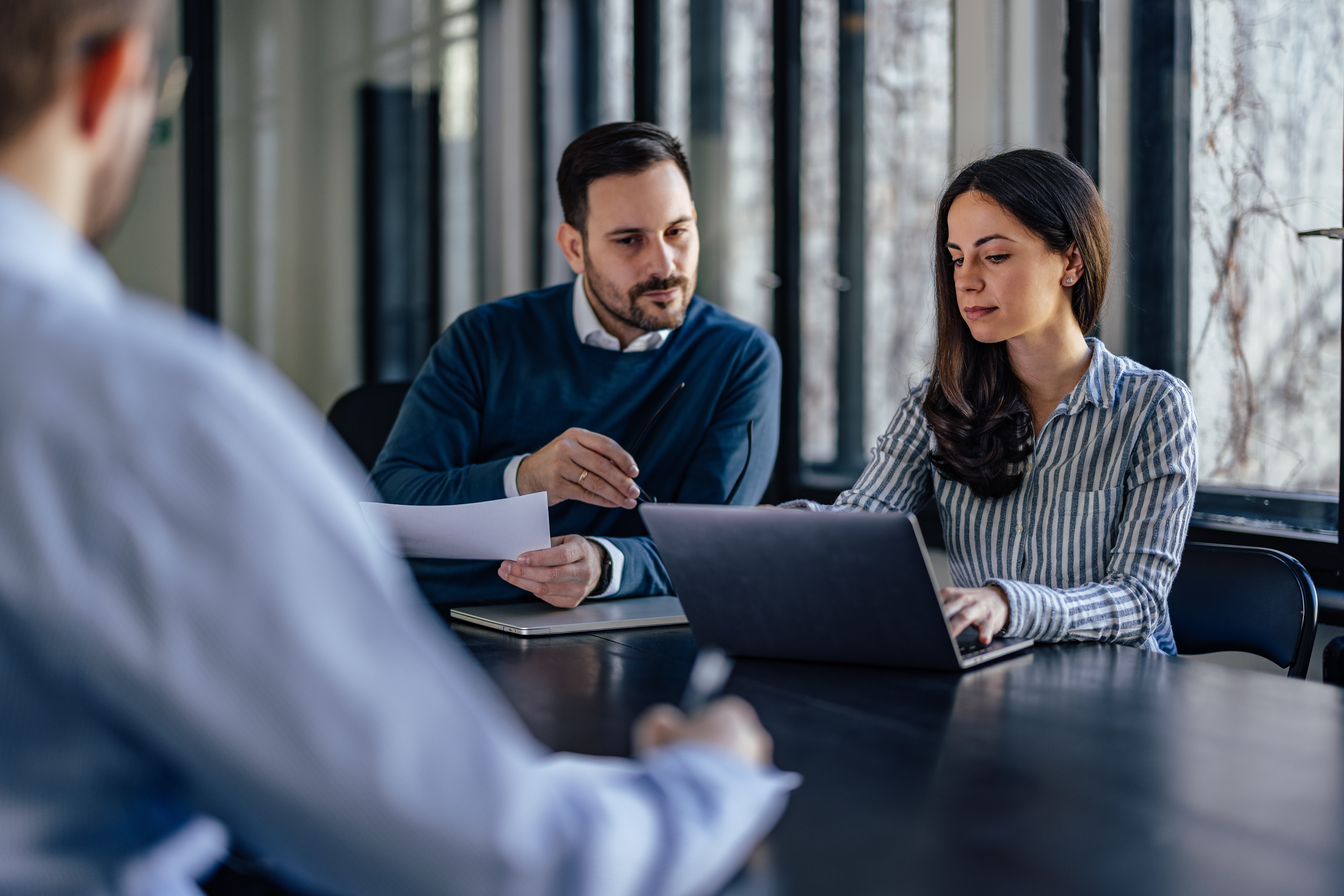 Data protection manager advising a colleague during a work session, representing privacy governance and data protection embedded in everyday management processes.